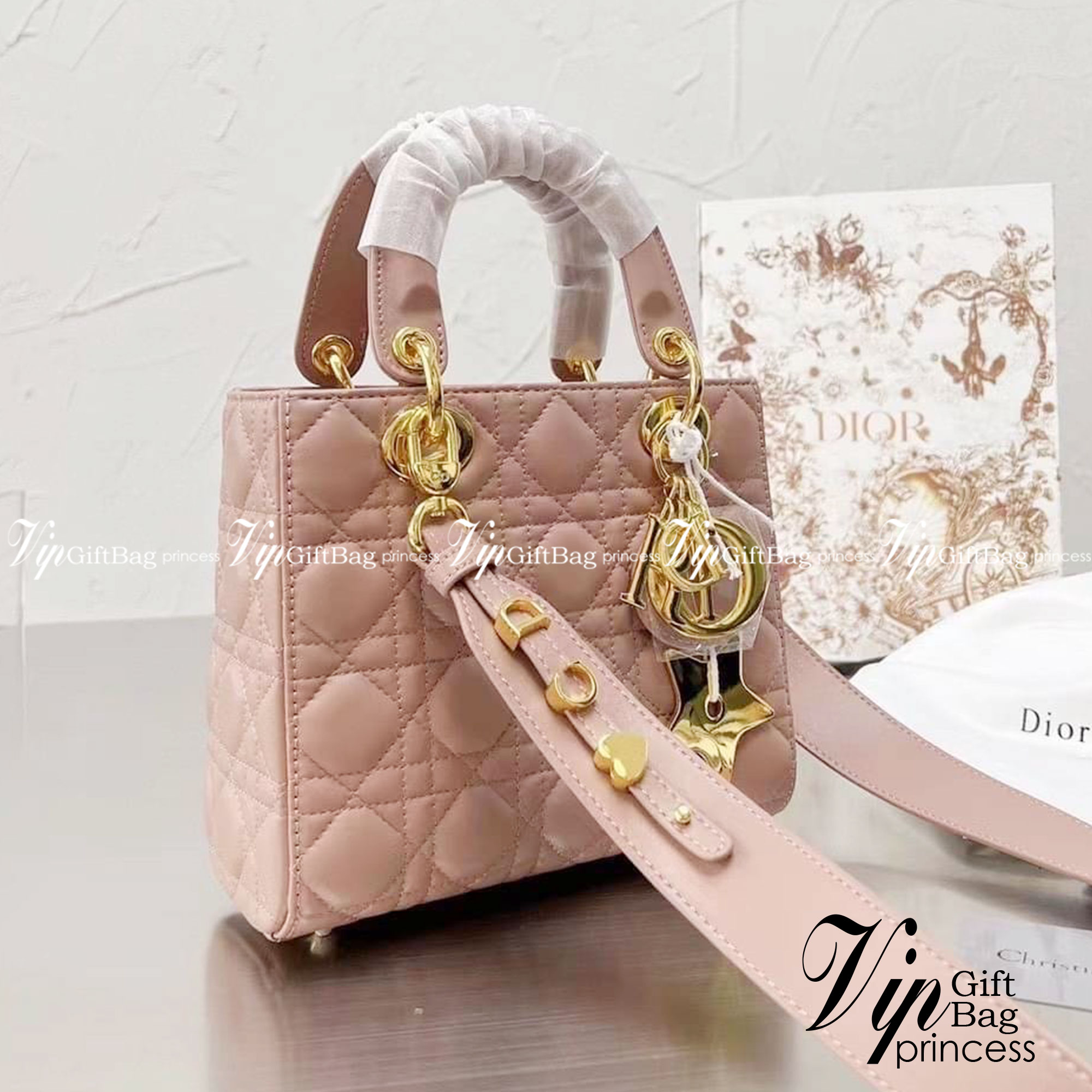 DIOR Lady / Small Lady Dior Bag Cannage Lambskin กระเป๋าสุดไอคอนิก รูปทรงสีเหลียม ขนาดกระทัดรัด ตั้งอยู่ทรง ฐานกระเป๋าแข็งแรง มีหมุดรองฐาน ดีไซน์เอกลักษณ์เฉพาะตัว ด้านหน้าตกแต่งด้วยตัวอักษร D.I.R ห้อยเป็นพวงกุญแจ จะถือหรือสะพายไหล่ก็ดูดีมากๆ ค่ะ