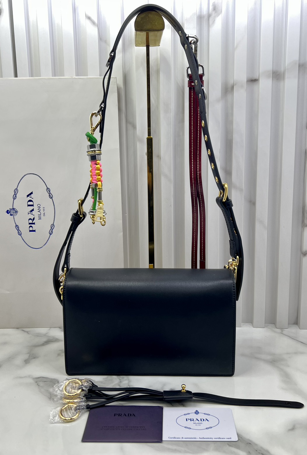 ORI หนังแท้ | 22cm Prada Soft Sound small leather shoulder bag with charms กระเป๋าสะพายทรงกล่อง รุ่นใหม่ล่าสุด มาแรงแบบเกินต้าน ด้วยดีไซน์เรียบ แต่มีกิมมิคเท่ห์ๆ ที่สายและพวงห้อยหลากสีสุดคิวท์
