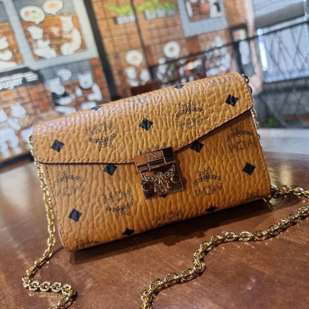 M.C.M SMALL MILLIE FLAP CROSSBODY IN VISETOS ไซส์ใหม่พกพาสะดวก!! กระเป๋าสะพายกึ่งคลัทช์ รอบนี้มาไซส์สวย สามารถใช้แทนกระเป๋าสตางค์ได้เลย ใส่โทรศัพท์มือถือได้ทุกรุ่น ใส่ของสำคัญสบายๆ มาพร้อมสายสะพายโซ่สีทองหรูหรา รูปทรงดีไซน์ร่วมสมัย ใช้งานง่ายด้วยตัวล็อค ว