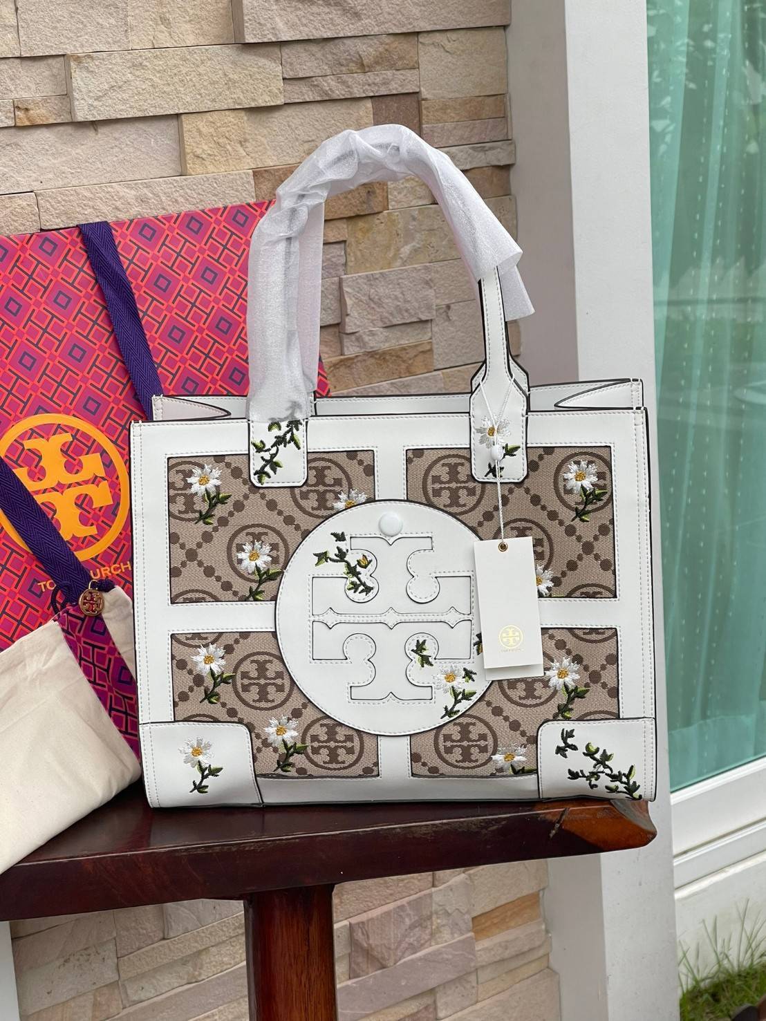 Tory burch ella jacquard embroidered quadrant tote ลายโมโนแกรม (Monogram) สัญลักษณ์สุดโดดเด่นที่คิดค้นขึ้นมาเพื่อให้แบรนด์มีเอกลักษณ์ สำหรับรุ่นนี้เป็นกระเป๋าที่ใส่ของได้เยอะ สามารถใส่สิ่งของที่จำเป็นสำหรับการทำงานได้ ง่ายต่อการถือและการหยิบใช้ข้าวของในกร