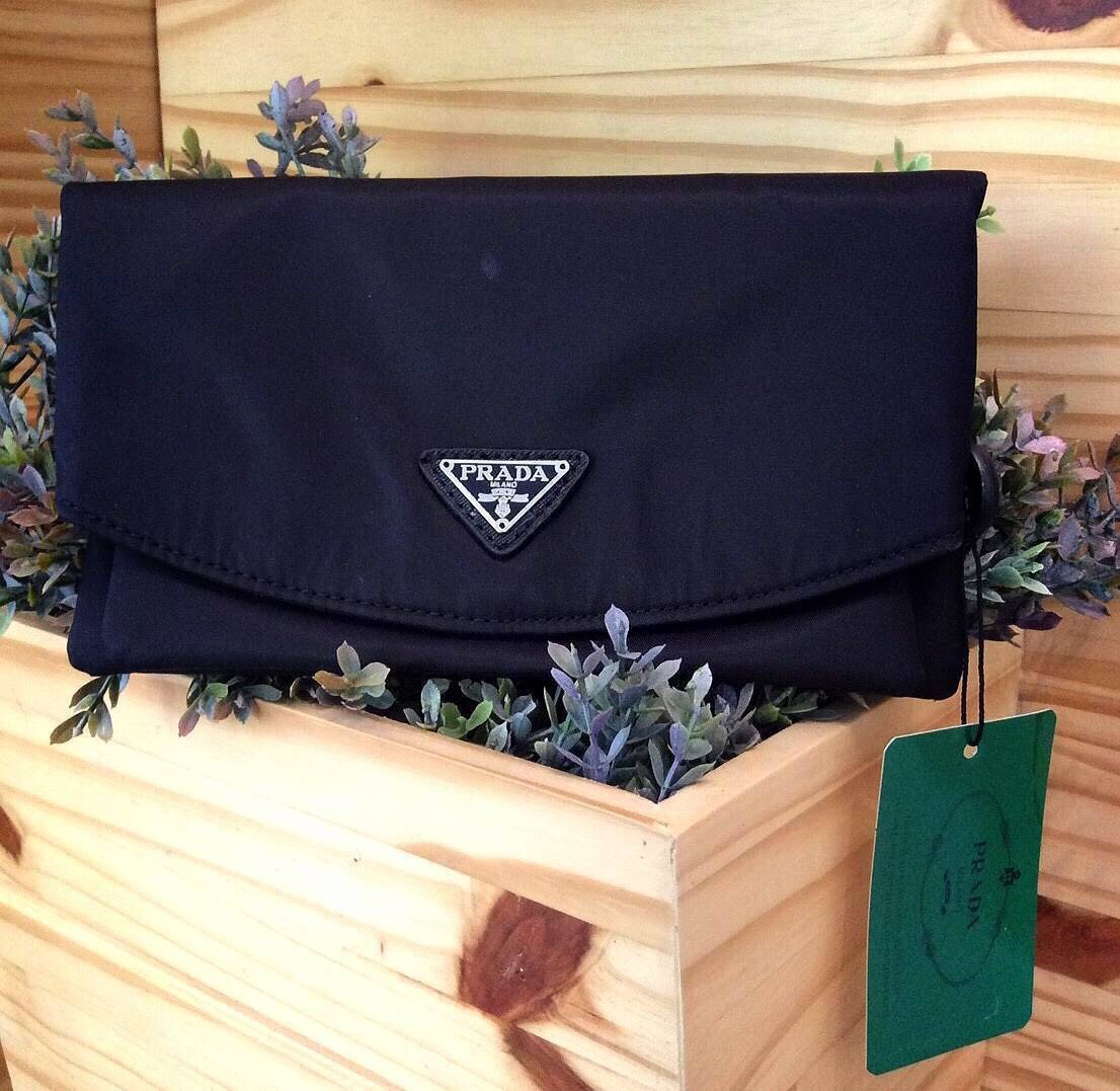 PRADA NYLON CLUTCH กระเป๋าคลัชพร้อมสายคล้องมือพรีเมี่ยมกิ้ฟจากเคาน์เตอร์ต่างประเทศรุ่น Limited วัสดุ Nylon เนื้อหนาคุณภาพดีตามแบบฉบับแบรนด์ ด้านหน้าประดับโลโก้แบรนด์หรู ภายในมีช่องใหญ่1ช่อง มีช่องซิป2ช่อง หัวซิปปั้มโลโก้ ซับใน Polyester สกรีนโลโก้ สามารถใ