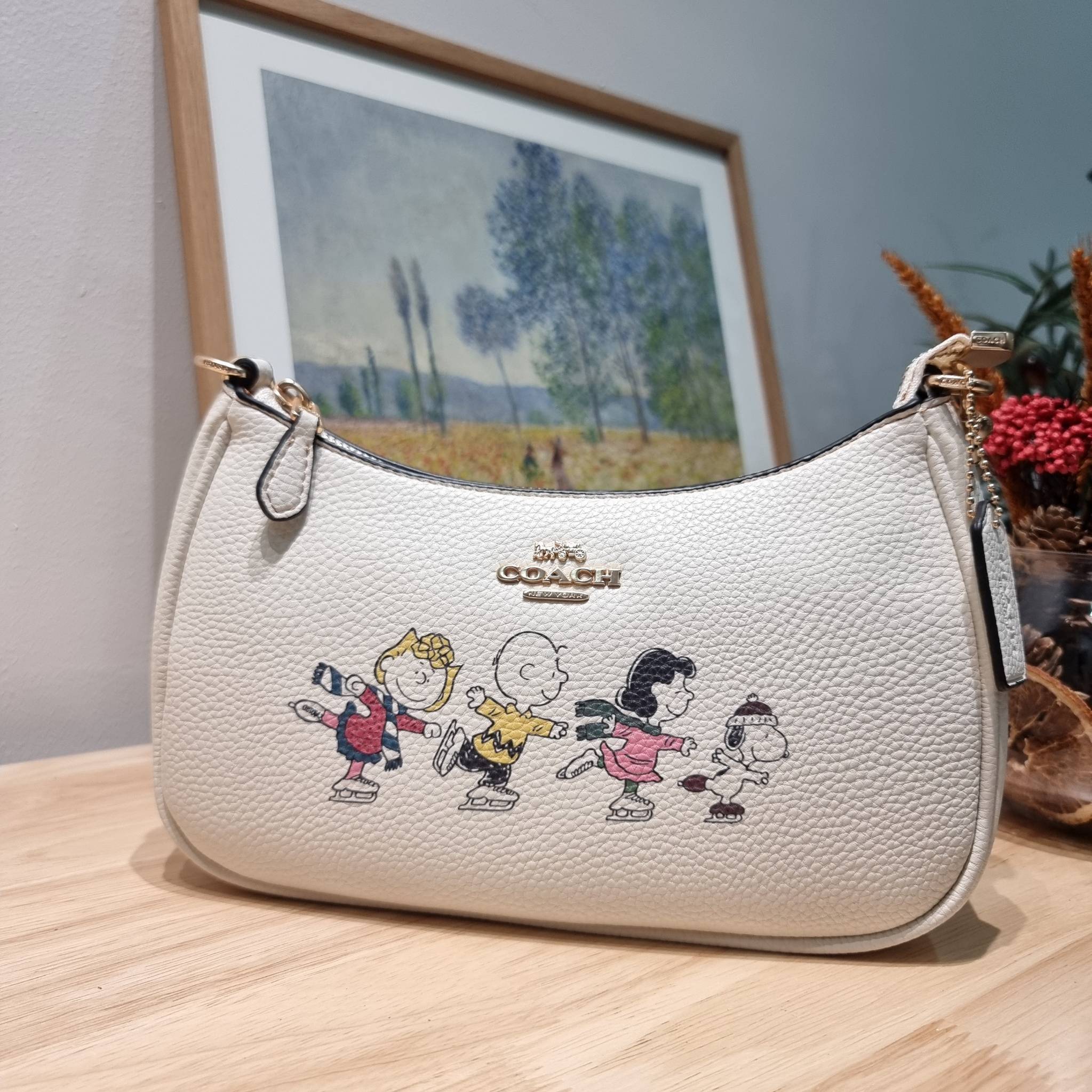 Coach X Peanuts Teri Shoulder Bag With Snoopy And Friends Motif CE861 คอลเลคชั่นสุดคิ้วท์ ไม่ให้ช้อปยังไงไหว!! กับกระเป๋าสะพายไหล่กึ่งทรงพอช พร้อมเสิร์ฟความสวยถึงบ้านไปเลยก่อนใคร แบบไม่ต้องพรีฯ ด้วยดีไซน์ลวดลายกาน์ตูนยอดฮิต มาพร้อมสายสะพาย 2 เส้น
