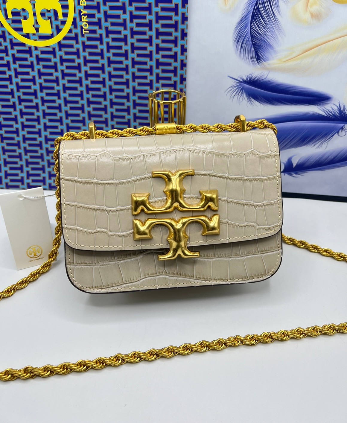 6 สี Tory Burch Croc Eleanor Small Bag / TORY BURCH ELEANOR CROC EMBOSSED LEATHER กระเป๋าสะพายหนังพิมพ์ลายจระเข้ ดีไซน์หรูหรา โด่นเด่นด้วยโลโก้แบรนด์อะไหล่ด้านหน้า และสายสะพายโลหะสีทอง