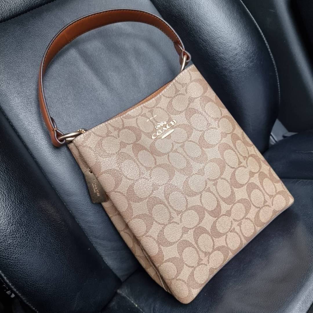 COACH 2312 SMALL TOWN BUCKET BAG IN SIGNATURE CANVAS รุ่นยอดนิยมใบเล็กมาครบสีแล้วจ้า กระเป๋าทรงบัคเก็ต สีผู้ดี๊ผู้ดี ตัวกระเป๋าดีไซน์คลาสสิคลายซี ดูโดดเด่น วัสดุหนังแคนวาสเคลือบลาย สวยคมทุกมุมจริงๆ!! เปิด-ปิดด้วยกระดุมแม่เหล็กทั้ง 2 ฝั่ง ภายในเป็นช่องโล่ง