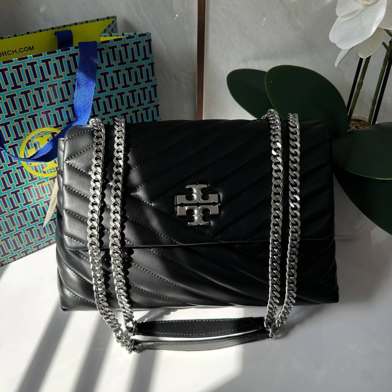 TORY BURCH KIRA CHEVRON CONVERTIBLE SHOULDER BAG กระเป๋าสะพายไซส์ใหญ่ หรูหราสุดคลาสสิก วัสดุหนังแกะทั้งใบ เปิด-ปิดด้วยกระดุมแม่เหล็ก ภายในเป็นช่องโล่ง ใส่ของสำคัญได้ครบ สายสะพายในตัวปรับได้ 2 แบบ สะพายไหล่โซ่คู่หรือจะ ครอสบอดี้ก็เริ่ดคะ