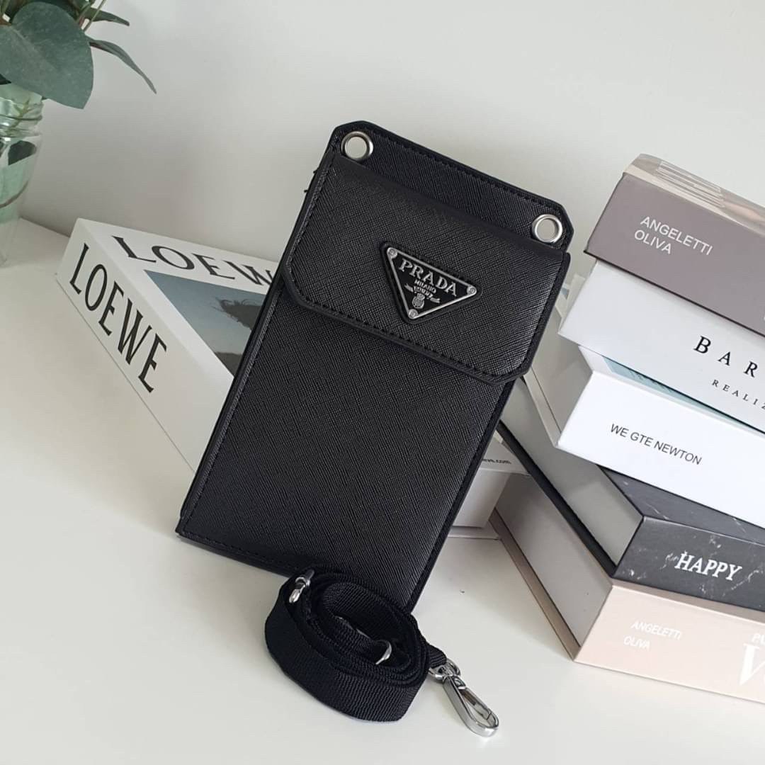 PRADA PHONE CASE ไอเท็มสุดคลาสสิคที่ทุกท่านควรมี! Prada Saffiano Leather Smartphone Case งานพรีเมี่ยมกิ้ฟท์จากเคาเตอร์ต่างประเทศ ของมีจำนวนจำกัด หนังลาย saffiano อยู่ทรงสวย ดีไซน์หรูหรา ดูดี ทรงCrossbody ด้านหน้ามีโลโก้แบรนด์ อะไหล่ทอง ด้านในเปิดปิดด้วยกร