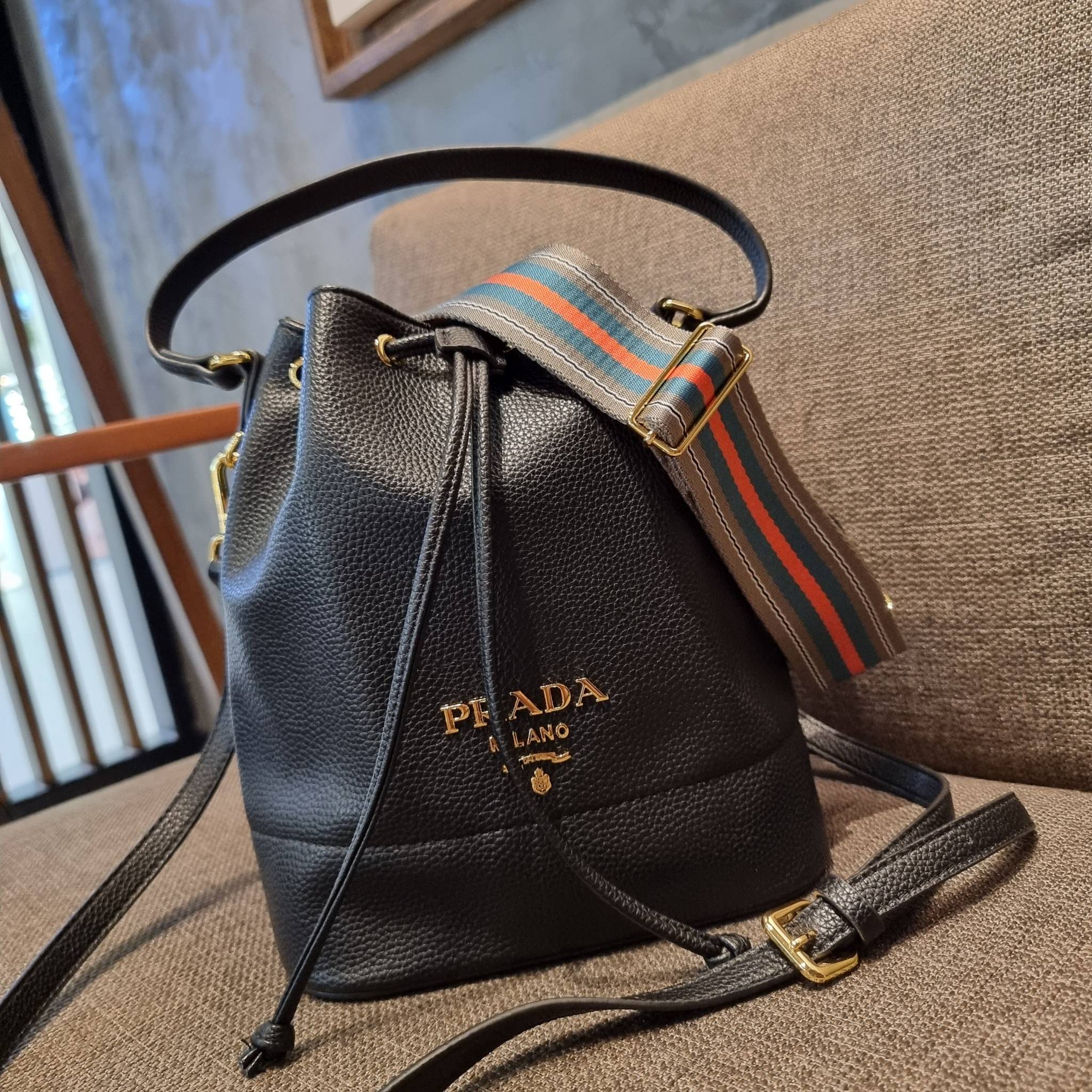 Prada leather bucket bag กระเป๋าสะพายทรงขนมจีบ ดีไซน์เรียบ แต่หรู น่าใช้มากๆ หนังสวยมาก วัสดุหนัง pepble สัมผัสนิ่มมือ ตกแต่งโลโก้สีทองตัดหนังดำ คือเลิศ!! ปากกระเป๋ารูดเปิดปิดได้ สะดวกใช้งาน ภายในโล่งกว้าง จุของได้เยอะ ไม่ธรรมดาเลย พิเศษ!! นอกจากสายคล้องใ