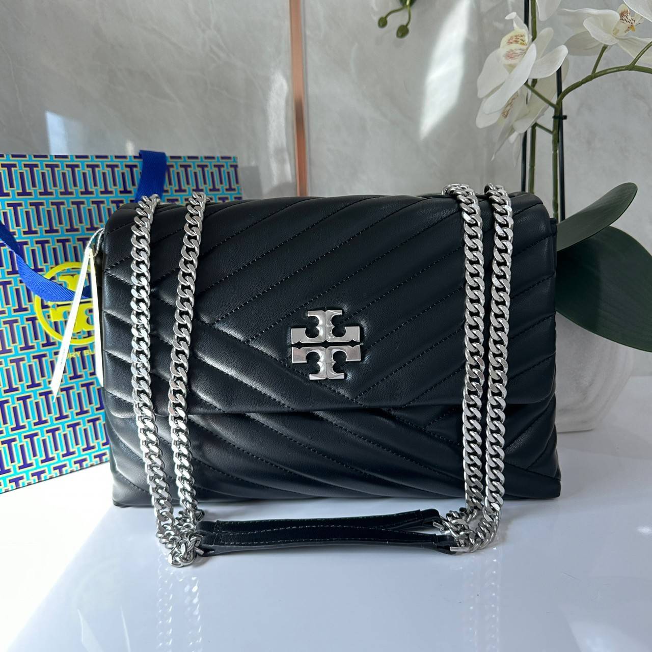 TORY BURCH KIRA CHEVRON CONVERTIBLE SHOULDER BAG กระเป๋าสะพายไซส์ใหญ่ หรูหราสุดคลาสสิก วัสดุหนังแกะทั้งใบ เปิด-ปิดด้วยกระดุมแม่เหล็ก ภายในเป็นช่องโล่ง ใส่ของสำคัญได้ครบ สายสะพายในตัวปรับได้ 2 แบบ สะพายไหล่โซ่คู่หรือจะ ครอสบอดี้ก็เริ่ดคะ