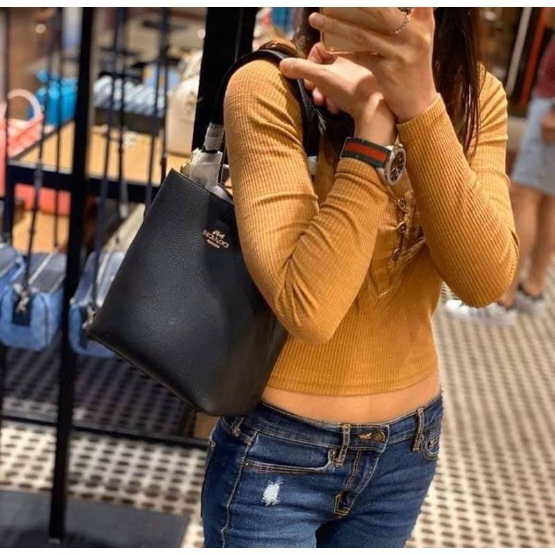 COACH 1011 SMALL TOWN BUCKET BAG รุ่นยอดนิยมใบเล็ก กระเป๋าทรงบัคเก็ต สีคลาสสิคเรียบหรู ตัดกับโลโก้สีทองดูโดดเด่น วัสดุหนัง pepble สวยคมทุกมุมจริงๆ!! เปิด-ปิดด้วยกระดุมแม่เหล็กทั้ง 2 ฝั่ง ภายในเป็นช่องโล่ง มาพร้อมสายสะพายปรับได้ตามตัว ขนาดใบนี้กำลังสวย สะพ