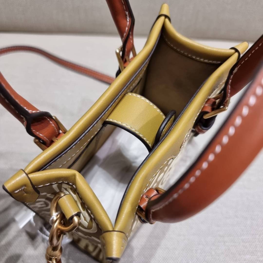TORY BURCH T MONOGRAM EMBOSSED MINI TOTE สุดหรูกับกระเป๋าสะพายทรงโท้ท ไซส์มินิ ที่สร้างความหรูหราให้ตัวกระเป๋าด้วยดีเทลลายนูน แต่งแต้มลวดลายเอกลักษณ์ สีลูกคุณมากๆ!! วัสดุหนังแท้ ผิวสัมผัสดี ปากกระเป๋ามีแถบแม่เหล็กกันของหล่นได้ ภายในโล่ง ใส่ของจำเป็นได้ โท