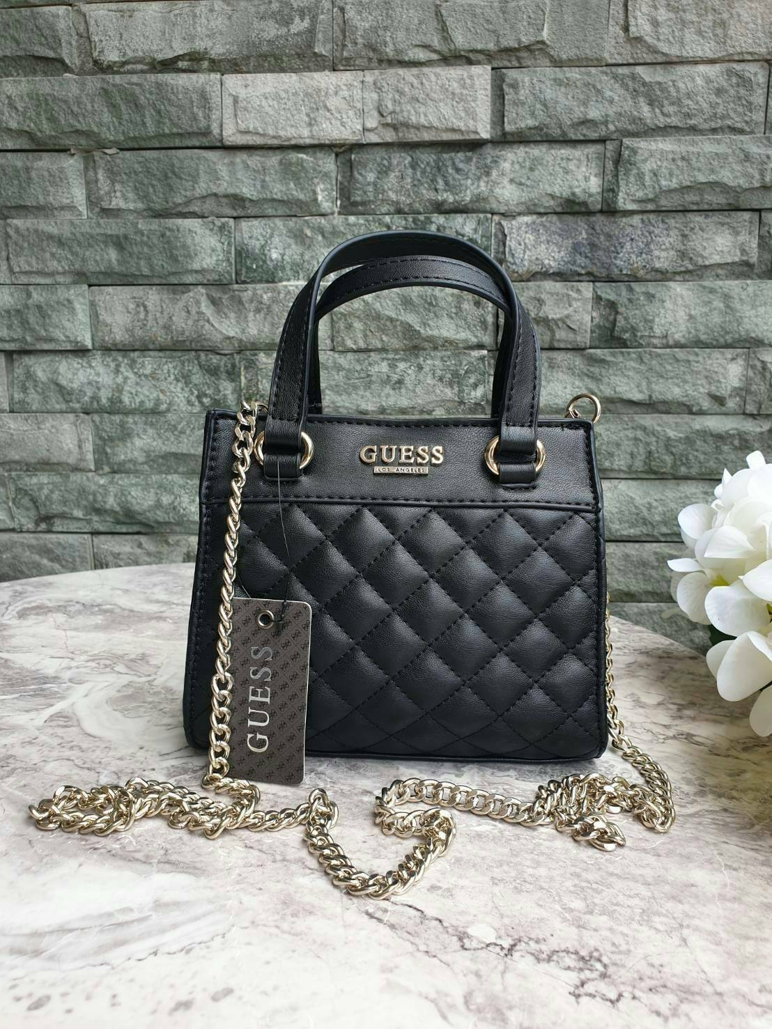 GUESS TAYLOR MINI SATCHEL CROSSBODY BAG กระเป๋าสะพายใบเล็ก สไตล์ สวยหรู คุณหนู ไฮโซ น่ารักมากๆ วัสดุหนังpu เย็บลายตาราง หนังนิ่ม จับนุ่มมือ และ ลายทาง หนัง saffiano ตั้งอยู่ทรง แบบน่ารักไม่ซ้ำใคร ด้านหน้าประดับโลโก้แบรนด์ อะไหล่ทอง มาพร้อมสายโซ่ ถอดออกได้