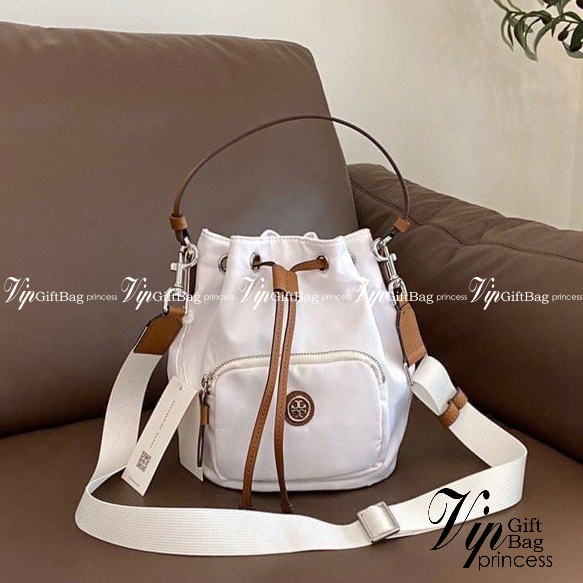 Tory Burch Virginia Nylon Bucket Bag / Tory Burch logo-plaque bucket bag กระเป๋าสะพายทรงบัคเก็ต เปิด-ปิดหนังรูดปากกระเป๋า มีหูหิ้วในตัว คล้องแขนเก๋ๆ ภายในเป็นช่องโล่ง มีช่องย่อย ใส่ของสำคัญจุกจิกได้ มีสายครอส จะสะพายไปไหนก็ได้ทุกโอกาส สวยเลิศทุกสี พร้อมส่