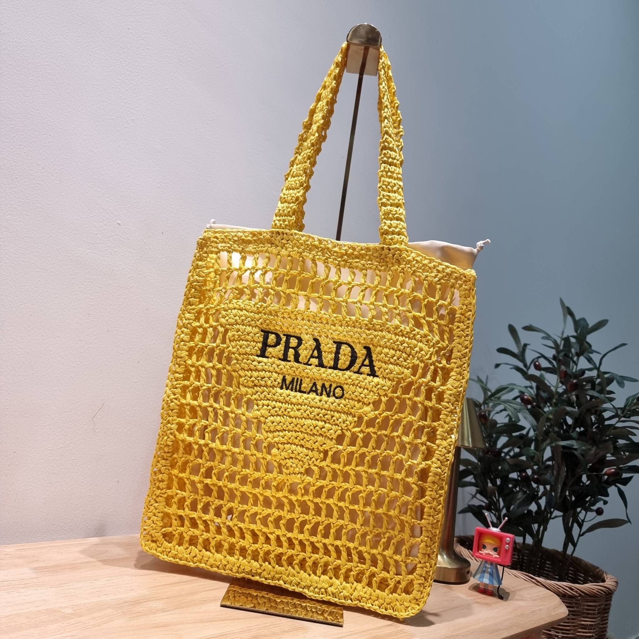 PRADA RAFFIA TOTE BAG สวยไม่ซ้ำใคร สไตล์บีช เหมาะมากกับการสะพายไปเที่ยวทะเล หรือจะใช้ในวันสบายๆก็ตอบโจทย์ กับกระเป๋าสะพายสานใบใหญ่ ตัวกระเป๋าเป็นวัสดุสังเคราห์จากธรรมชาติ