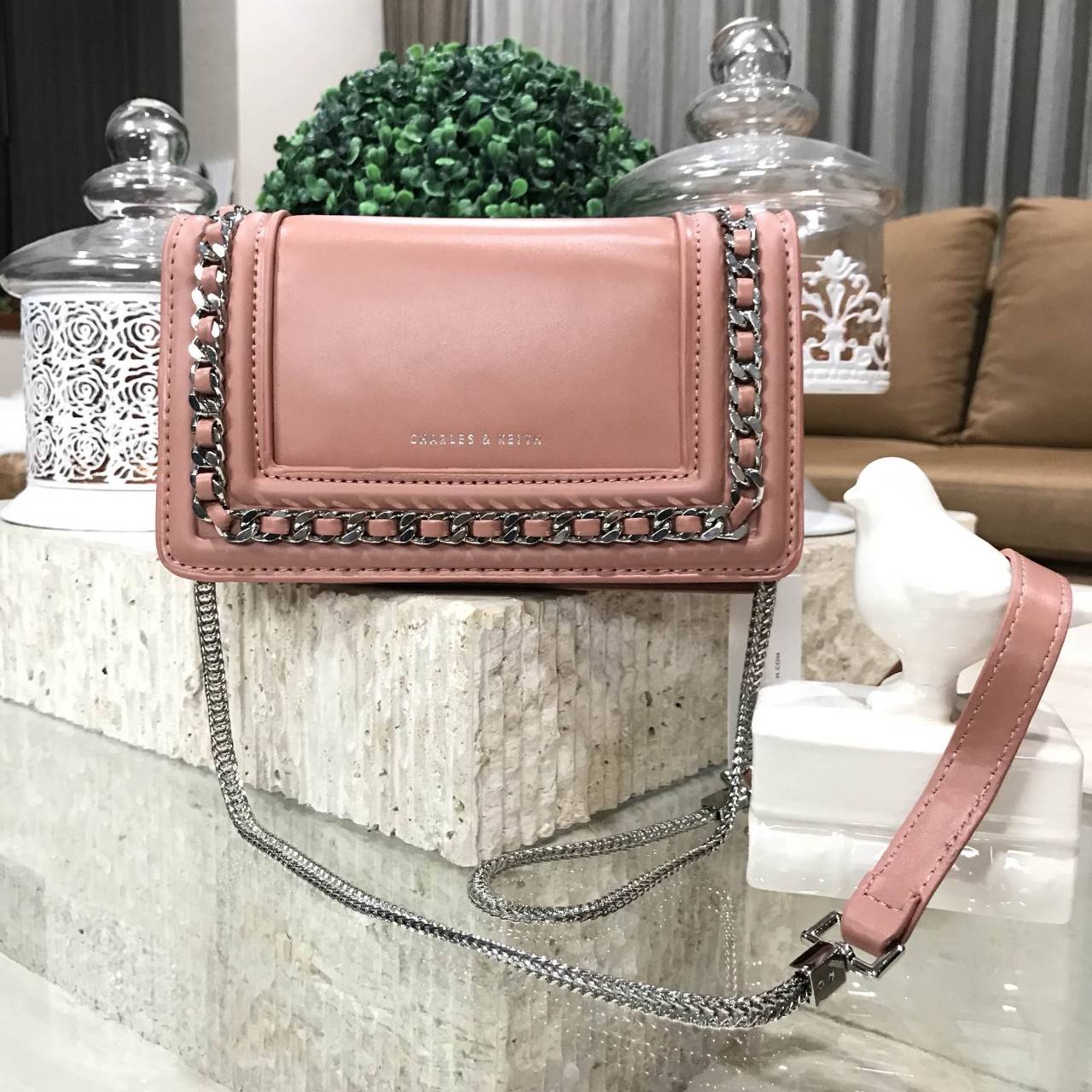 NEW ARRIVAL! CHARLES & KEITH CHAIN DETAIL CROSSBODY BAG กระเป๋าสะพายทรงสี่เหลี่ยมรุ่นชนช็อปขนาดกำลังดีวัสดุหนังนิ่มเรียบประดับด้วยโซ่ด้านหน้าดูมีดีเทล เปิดปิดด้วยกระดุมแม่เหล็ก ภายในมีช่องใส่บัตรและช่องซิป มาพร้อมสายโซ่ต่อหนังถอดถือเป็นคลัชได้ ภาพถ่ายสินค