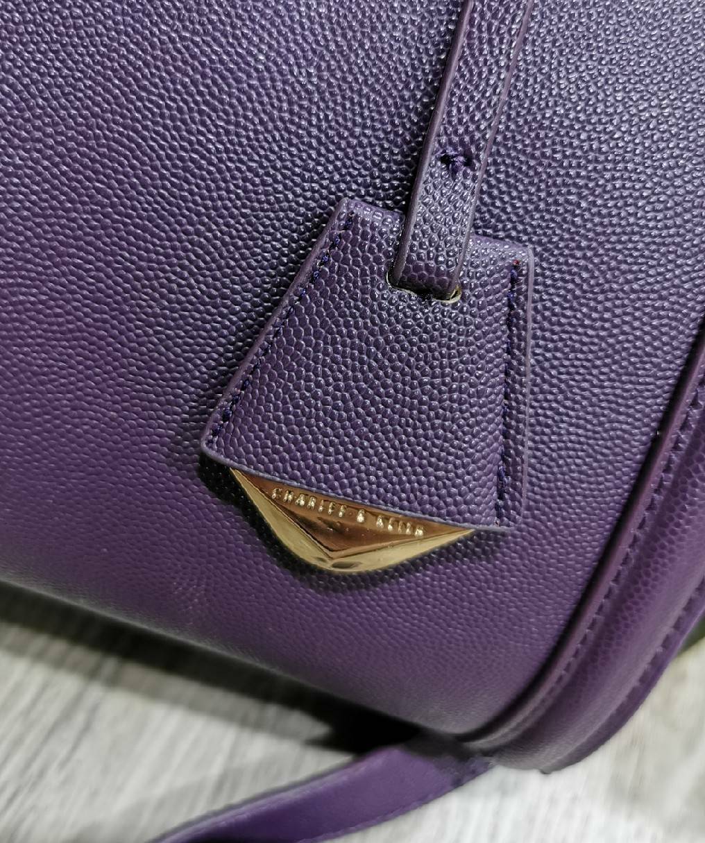 CHARLES & KEITH SAFFIANO TRAPEZE BAG กระเป๋าถือหรือสะพายรุ่นยอดนิยมดีไซน์สวยหรูวัสดุหนังคาเวียร์อยู่ทรง ด้านข้างเเต่งหนังช่องตัดดูมีดีเทล ด้านหน้ามีโลโก้ ด้านหลังมีช่องซิป เปิดปิดด้วยซิปหัวซิปแบรนด์ หูจับเเข็งแรง พับลงได้ พร้อมสายสะพายหนังปรับระดับได้ถอดไ