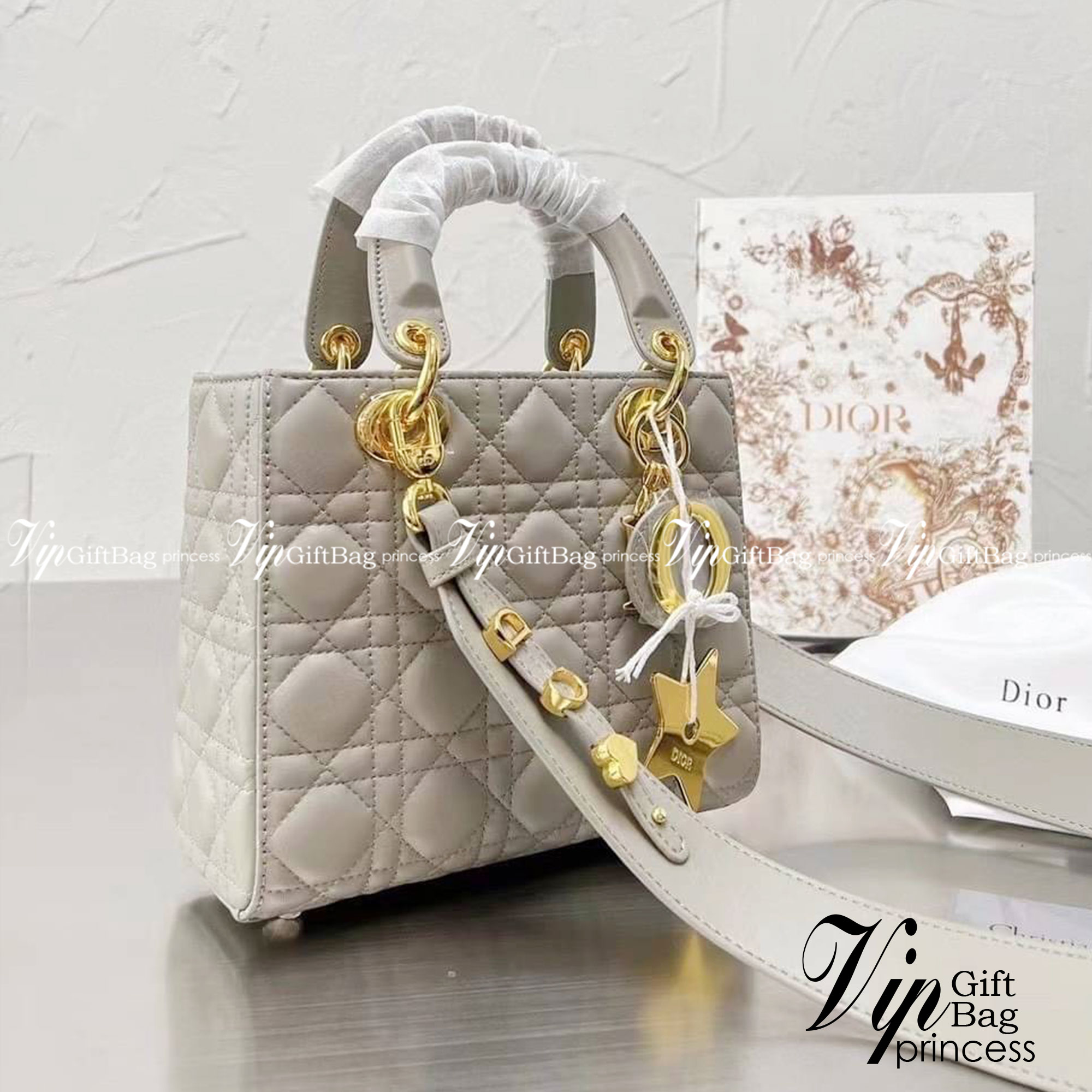 DIOR Lady / Small Lady Dior Bag Cannage Lambskin กระเป๋าสุดไอคอนิก รูปทรงสีเหลียม ขนาดกระทัดรัด ตั้งอยู่ทรง ฐานกระเป๋าแข็งแรง มีหมุดรองฐาน ดีไซน์เอกลักษณ์เฉพาะตัว ด้านหน้าตกแต่งด้วยตัวอักษร D.I.R ห้อยเป็นพวงกุญแจ จะถือหรือสะพายไหล่ก็ดูดีมากๆ ค่ะ