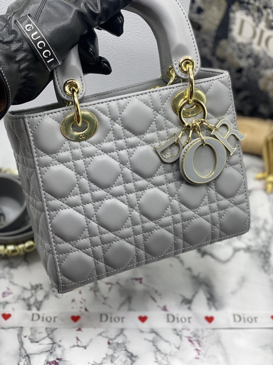 หนังแท้ DIOR LADY BAG 20cm ความสง่างามอีกหนึ่งรุ่นของ Dior รูปทรงสีเหลียม ขนาดกระทัดรัด ตั้งอยู่ทรง ฐานกระเป๋าแข็งแรง มีหมุดรองฐาน ดีไซน์ที่มีเอกลักษณ์เฉพาะตัว ด้านหน้าตกแต่งด้วยตัวอักษร D.I.R ห้อยเป็นพวงกุญแจ จะถือด้วยมือหรือสะพายไหล่ก็ดูดีมากๆ ค่ะ