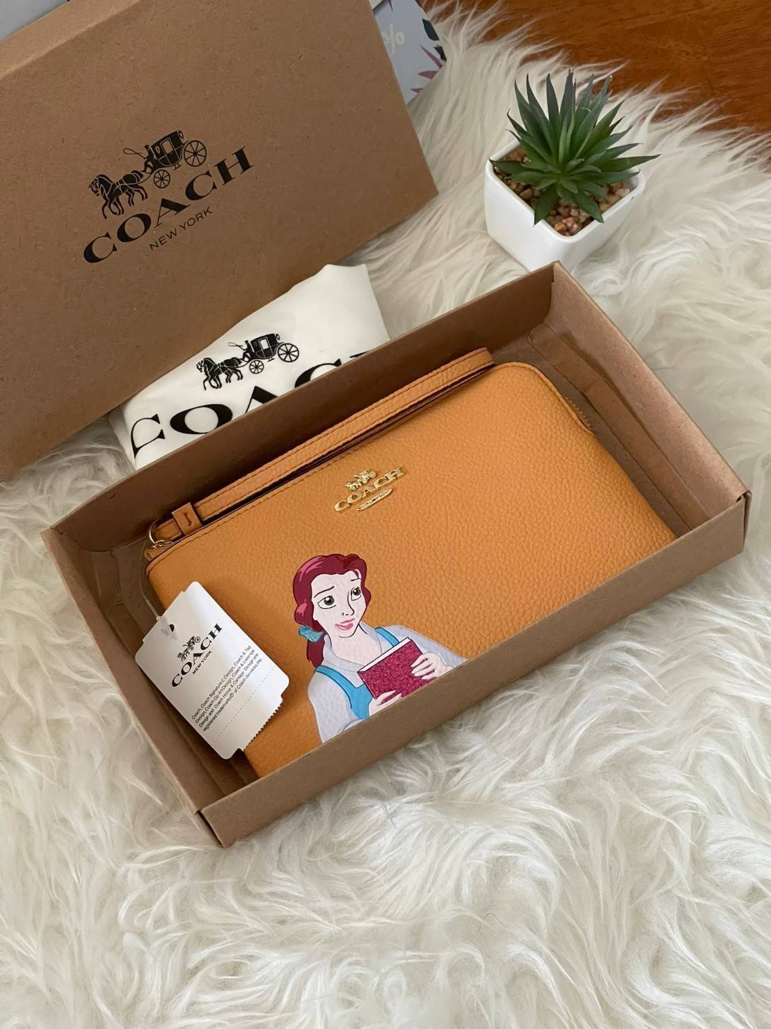 Coach & Disney Corner Zip Wristlet เปิดตัวคอลเลคชั่นเมื่อความดาร์กและโรแมนติกโคจรมาพบกัน เมื่อแบรนด์เครื่องหนังสัญชาติอเมริกัน Coach ร่วมมือกับ Disney สร้างสรรค์คอลเล็กชั่นพิเศษที่ได้รับแรงบันดาลใจมาจากเทพนิยายอเมริกันโกธิกของนิวยอร์ค ถ่ายทอดผ่านเหล่าตัวล