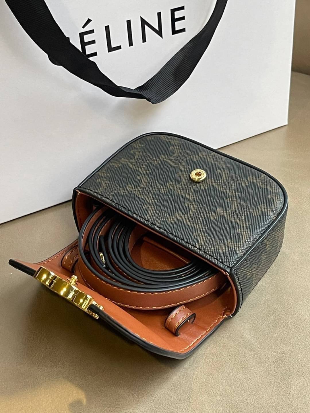 CELINE MINI TRIOMPHE IN TRIOMPHE CANVAS กระเป๋ามินิทรงชิค ดีไซน์รูปกล่องสุดแสนมินิมอล สามารถสะพายแบบ Crossbody และยังเป็น Belt Bagได้อีกด้วย วัสดุแคนวาสลาย Triomphe แบบไม่มีตกยุค ด้านหน้าโดดเด่นด้วยโลโก้สีทอง เป็นอีกหนึ่งตัวเลือกให้คุณเลือกสะพายในชีวิตประ