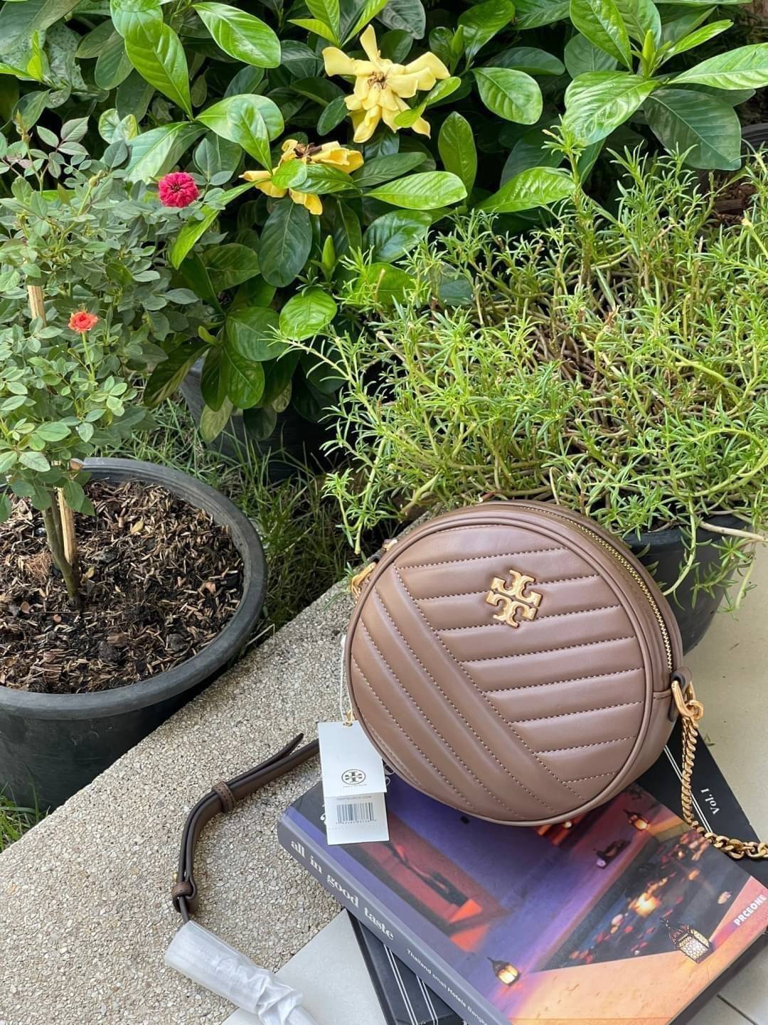 Tory burch Kira Cheron Circle Crossbody กระเป๋าสะพายคาดลำตัวรุ่นนี้โดดเด่นด้วยรูปทรงกลมสุดชิค ขนาดกะทัดรัด พร้อมด้วยหนังกระเป๋าที่ทำจากหนังแท้คุณภาพดี เพราะ Kira Chevron เป็นรุ่นที่ตอบโจทย์และครองใจสาว ๆ ได้อย่างแท้จริง เนื่องจากมีดีไซน์เรียบหรู โดยทางแบร