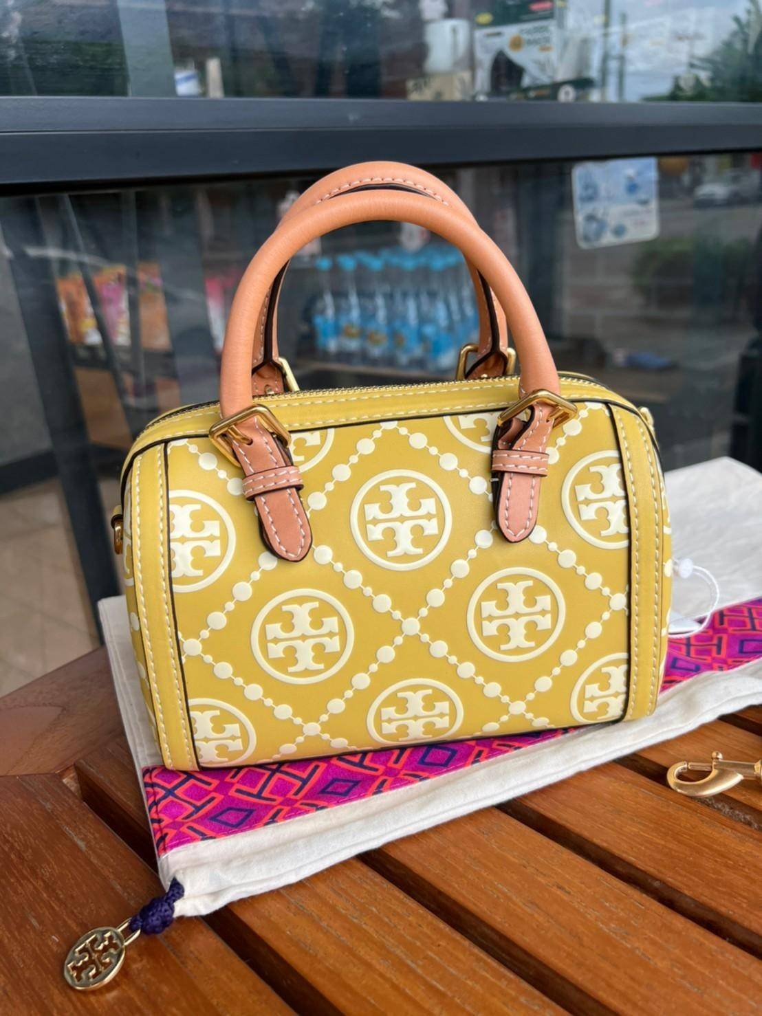 Tory Burch T-Monogram Mini Embossed Wine Bucket Bag / Tory Burch Mini Bucket กระเป๋าถือหรือสะพายไหล่ ทรงหมอนขนาดเล็ก ประดับด้วยลวดลายอันเป็นสัญลักษณ์ของแบรนด์ ถูกประดิษขึ้นด้วยความพิถีพิถันวัสดุหนังอย่างดี ด้านในบุด้วยหนังไมโครซูแอคเนื้อนุ่มทำความสะอาดง่า