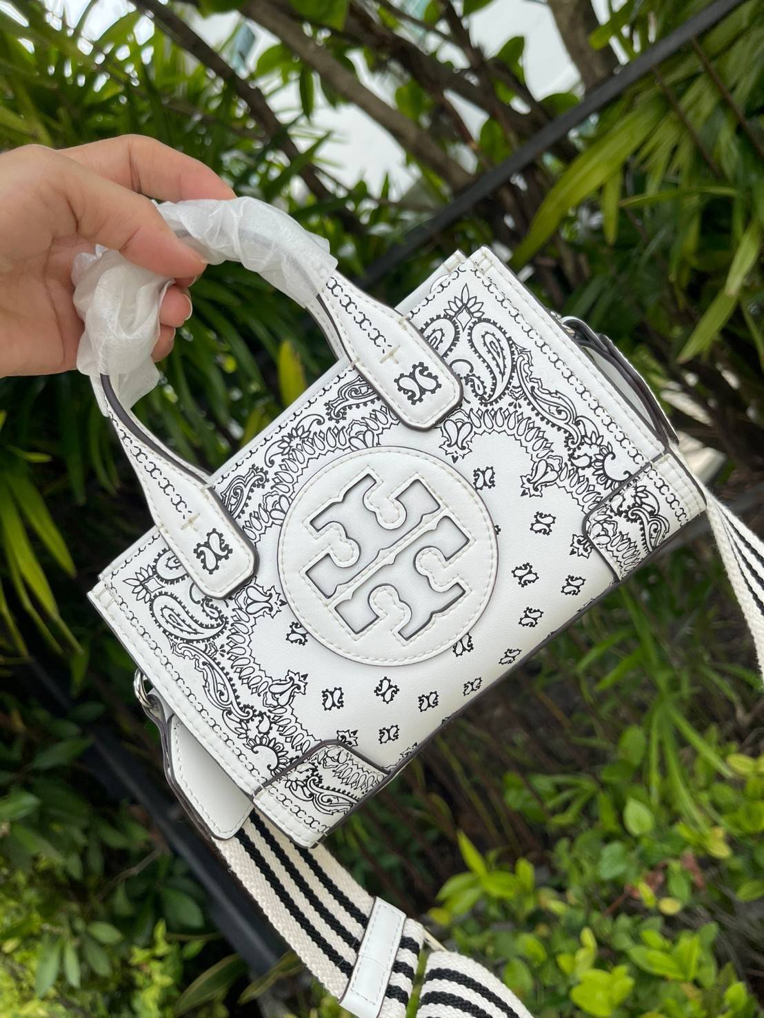 Tory Burch Ella Printed Leather Micro Tote Bag กระเป๋าขนาดมินิใบนี้บอกเลยว่าสไตล์เก๋และแปลกตาเลยทีเดียว กระเป๋าทรงสี่เหลี่ยมขนาดมินิ มีสายสะพายที่ออกแบบมาเข้ากับกระเป๋าสำหรับสะพายข้าง ลวดลายและสีสันบนกระเป๋ามีเอกลักษณ์ที่แสดงถึงความเป็นศิลปะแบบทอรี่โดยเฉพ