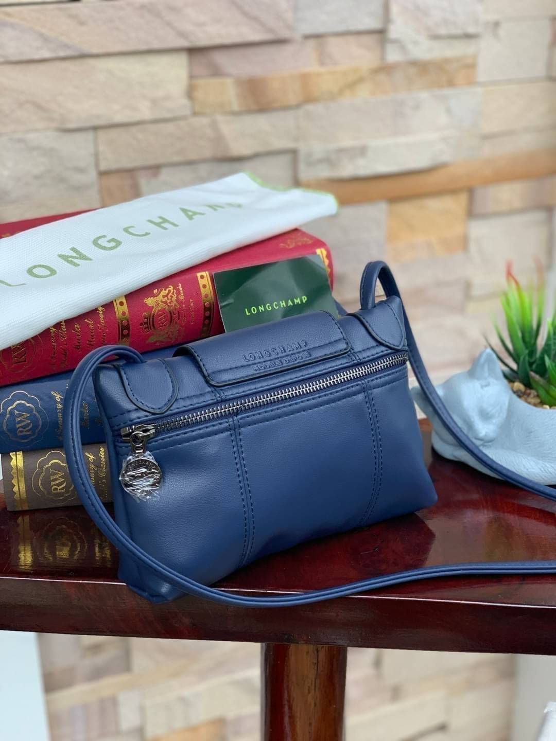 Longchamp Le Pliage Cuir Crossbody Bag อีกหนึ่งคอลเลคชั่น Le Pliage Cuir หนึ่งในตระกูลกระเป๋าสุดไอคอนิกจากแบรนด์ Longchamp และจัดการปรับดีไซน์ให้มีขนาดเล็กลงในทรงcrossbody กะทัดรัดสะพายแล้วคล่องตัว ด้วยดีไซน์ที่ดูเป็นเอกลักษณ์การใช้งานช่องหลักที่ซิปด้านหล