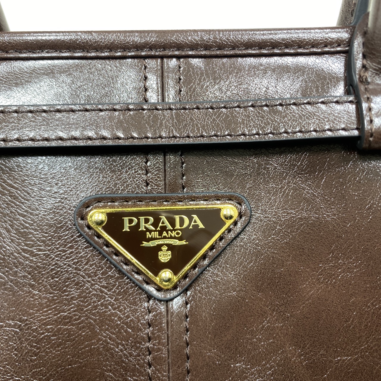 ORI หนังแท้ | Prada Bonnie medium leather handbag 32cm กระเป๋าสะพายทรงโท้ท โดดเด่นด้วยดีไซน์ที่เน้นความประณีตแต่ใช้งานได้จริง หนังเนื้อนุ่มเคลือบเงา เน้นย้ำเสน่ห์อันทันสมัยและใช้งานได้หลากหลาย