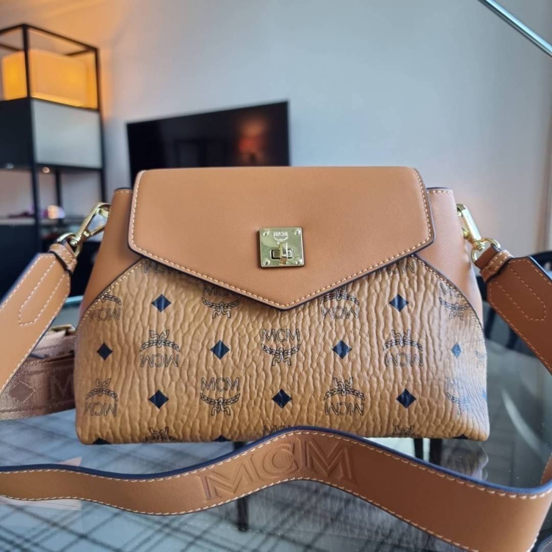 M.C.M ESSENTIAL CROSSBODY IN VISETOS กระเป๋าสะพายข้าง สวยอยู่ทรง ดีไซน์ไม่ซ้ำใคร มาพร้อมสายสะพายถึง 2 แบบ ปรับเปลี่ยนใช้ได้ไม่มีเบื่อ วัสดุหนังแคนวาสสลับหนังแท้ เปิด-ปิดกระเป๋าด้วยตัวบิดล็อคแน่นหนา ด้านหลังมีช่องเก็บบัตรได้ ภายในโล่งกว้าง แบ่งสัดส่วน เป็น