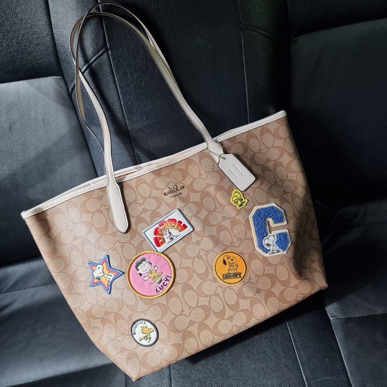 COACH C4292 COACHxPEANUTS CITY TOTE IN SIGNATURE CANVAS WITH VARSITY PATCHES กระเป๋าทรงโท้ทใบใหญ่ กับคอลเลคชั่นคอลแลบใหม่ล่าสุด น่ารักด้วยเหล่าผองเพื่อนสนู้ปพี สวยโดดเด่นมากๆ ใบนี้ใส่ของได้ของครบครัน จุได้แบบไม่ต้องกลัวเต็ม!! วัสดุหนังแคนวาสคุณภาพดี ปากกร
