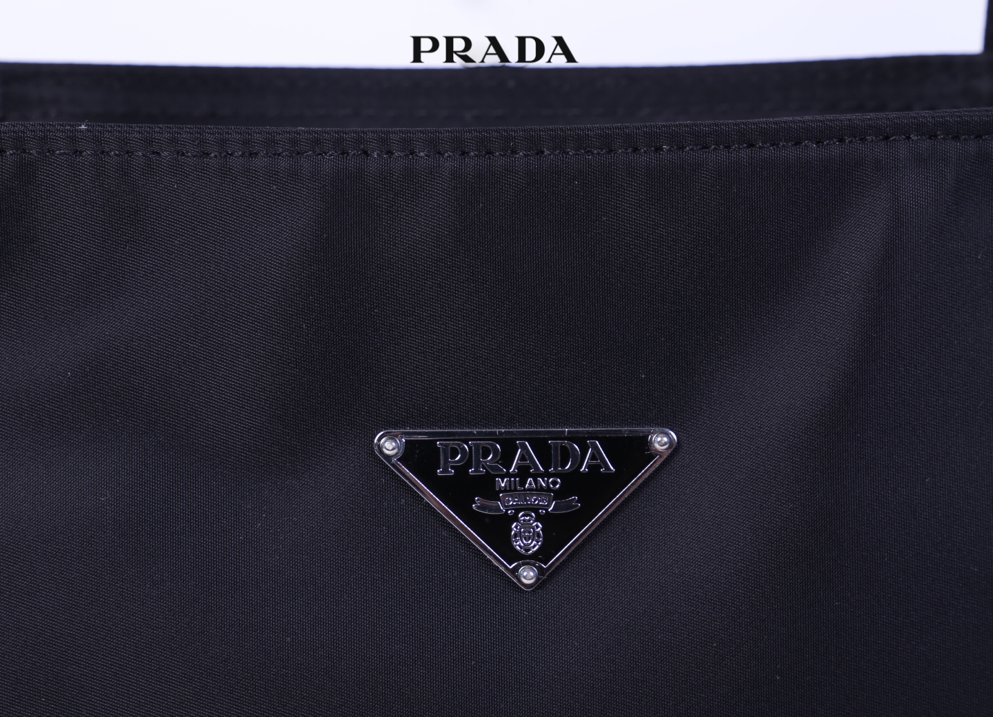 PRADA Shopping Bag / Prada Tessuto Tote Bag กระเป๋าสะพายไหล่ วัสดุ Nylon น้ำหนักเบา วัสดุทำจากไนลอนตัดกับหนัง ด้านหน้าประดับด้วยโลโก้แบรนด์