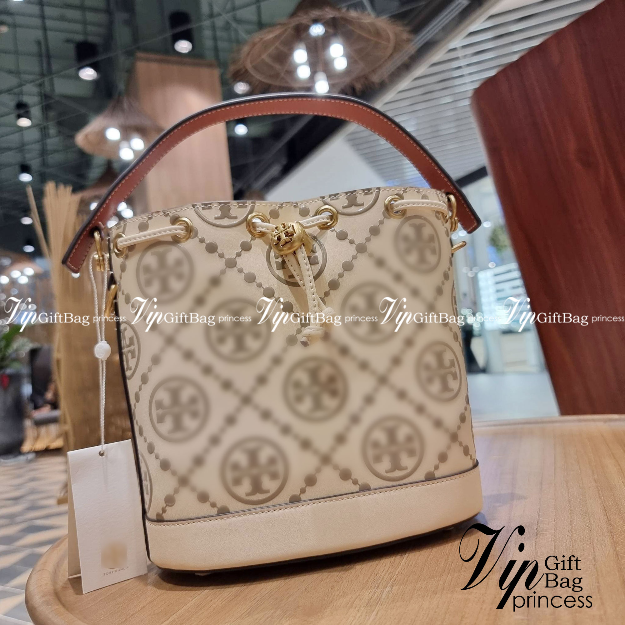 TORY BURCH T MONOGRAM EMBOSSED BUCKET BAG คอลเลคชั่นใหม่ กับกระเป๋าบัคเก็ตทรงยอดนิยม ดีไซน์ใหม่ล่าสุด สวยลูกคุณหนู หรูหรา!! ด้วยดีเทลผิวลายนูนลวดลายเอกลักษณ์ วัสดุหนังแท้ ปากกระเป๋ารูดเปิด-ปิดได้ มีหูจับในตัว สะดวกใช้ไปอีก และมีสายสะพายข้าง ปรับได้อีกด้วย
