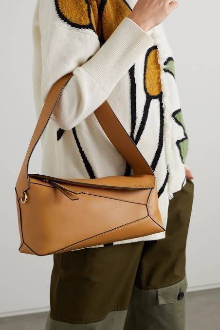 Loewe Puzzle Hobo bag กระเป๋ารุ่น Puzzle มีความพิเศษในหลายด้าน ไม่ว่าจะเป็นรูปทรงที่แปลกใหม่ มินิมอลด้วยโลโก้อนาแกรมแบบประทับ ดูหรู เป็นกระเป๋า Unisex ที่ไม่ว่าคุณจะเป็นผู้หญิงหรือผู้ชายก็ใช้งานได้ ลายกระเป๋าได้มาจากการนำหนังมาเย็บต่อกันทั้งหมด ถึงแม้ว่าข