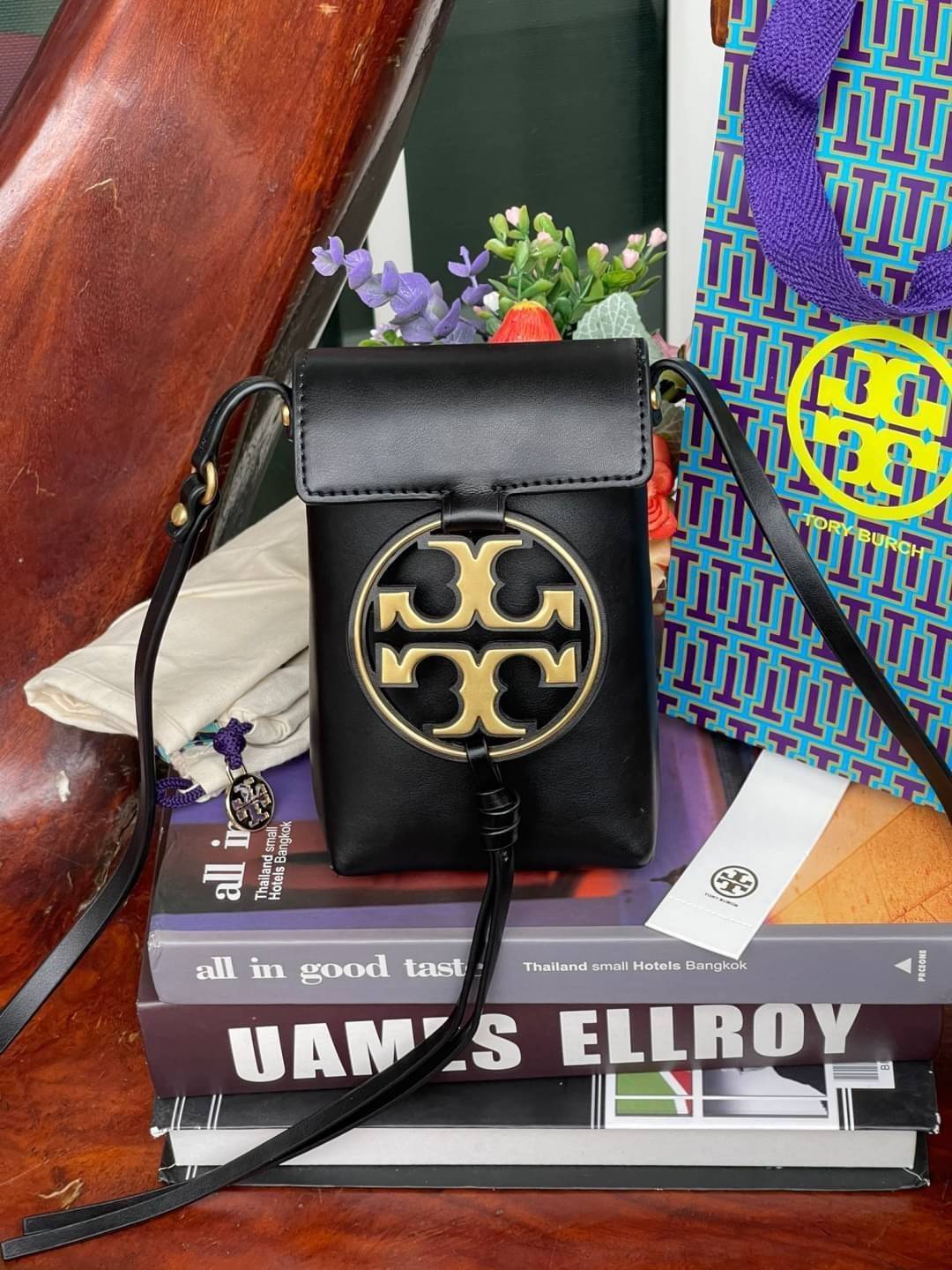 TORY BURCH MILLER METAL PHONE CROSSBODY อีกหนึ่งกระเป๋าใส่มือถือรุ่นฮิตที่เชื่อว่าหลาย ๆ คนต้องเคยเห็นผ่าน ๆ ตามาอย่างแน่นอน กับแบรนด์ Tory Burch ดีไซน์กระเป๋าทรงฝาพับแม่เหล็กใช้งานง่าย มาพร้อมดีเทล Logo แบรนด์โดดเด่นสีทองตัดกับหนังแกะสีดำ ดูหรูดูแพง! แต่