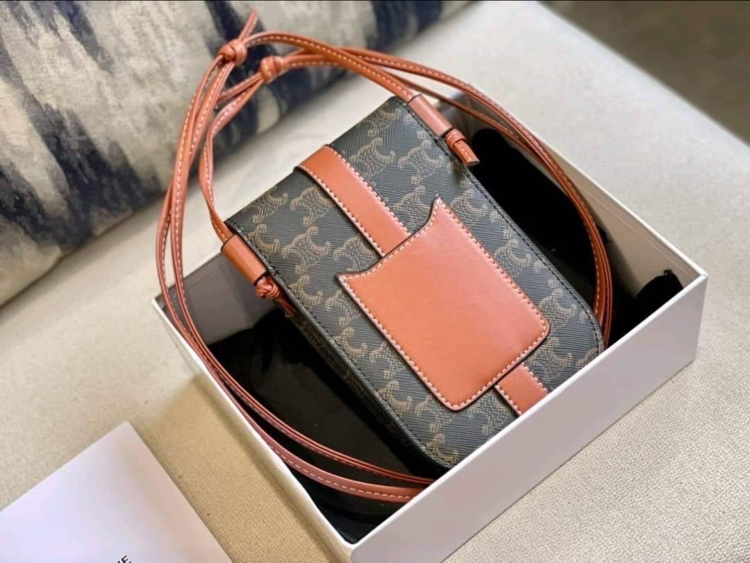Celine Phone Pouch in Triomphe Canvas and Calfskin Tan / Celine phone bag กระเป๋าใส่โทรศัพท์เรียบหรู ด้วยลวดลาย Triompe ที่แสดงถึงความเป็นเอกลักษณ์ของแบรนด์ ช่องหลักที่มีความกว้าง สามารถใส่โทรศัพท์มือถือ ธนบัตร บัตรต่าง ๆ และของจุกจิกชิ้นเล็ก ๆ ได้แบบจุใจ