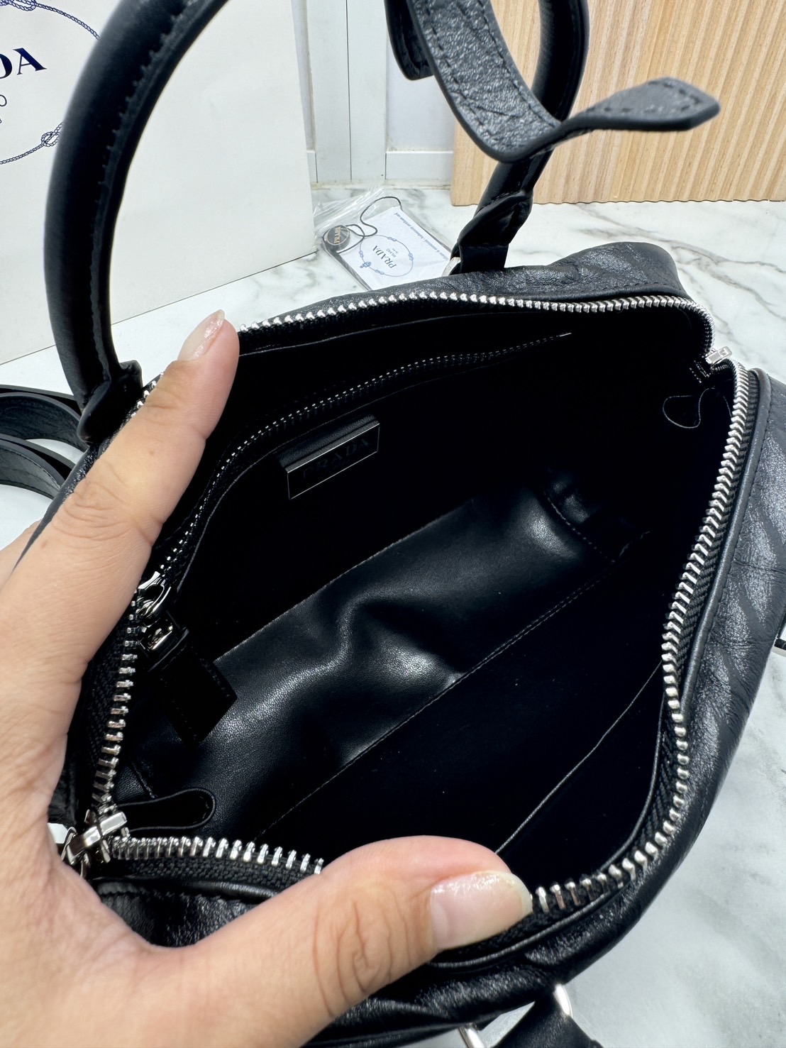 ORI หนังแท้ | Prada Small Top-handle Bag in Antique Nappa กระเป๋าสะพายพร้อมหูจับ งานหนังยับดีไซน์เอฟเฟกต์เท็กซ์เจอร์ที่มีเสน่ห์สไตล์วินเทจ พร้อมทริกห้อยเพิ่มสไตล์สัมผัสที่โดดเด่นและร่วมสมัยยิ่งขึ้น