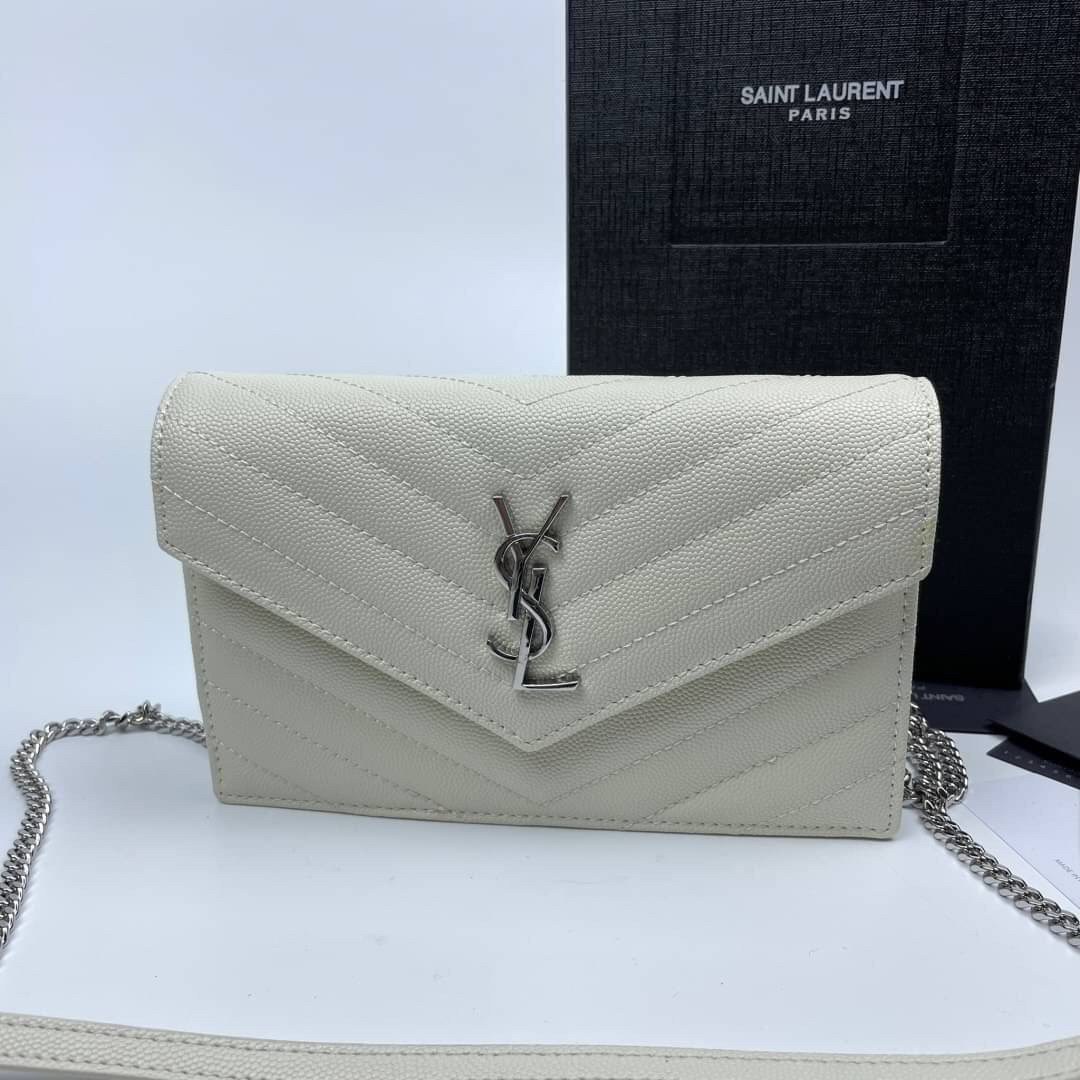 หนังแท้ YSL Yves Saint Laurent Envelope WOC 7.5” รุ่นฮอตปรอทแตก ทรงฐานตั้งได้ เป็นการดีไซน์กึ่งกระเป๋าสตางค์ ที่มาพร้อมสายสะพายยาว (เป็นสายโซ่ที่ต่อกับหนัง) สายถอดได้ (ปรับระดับไม่ได้) ถือเป็นคลัชก็สวยมากเลยค่ะ เป็นอีกหนึ่งรุ่นที่ให้ความรู้สึกเรียบแต่โก้ห