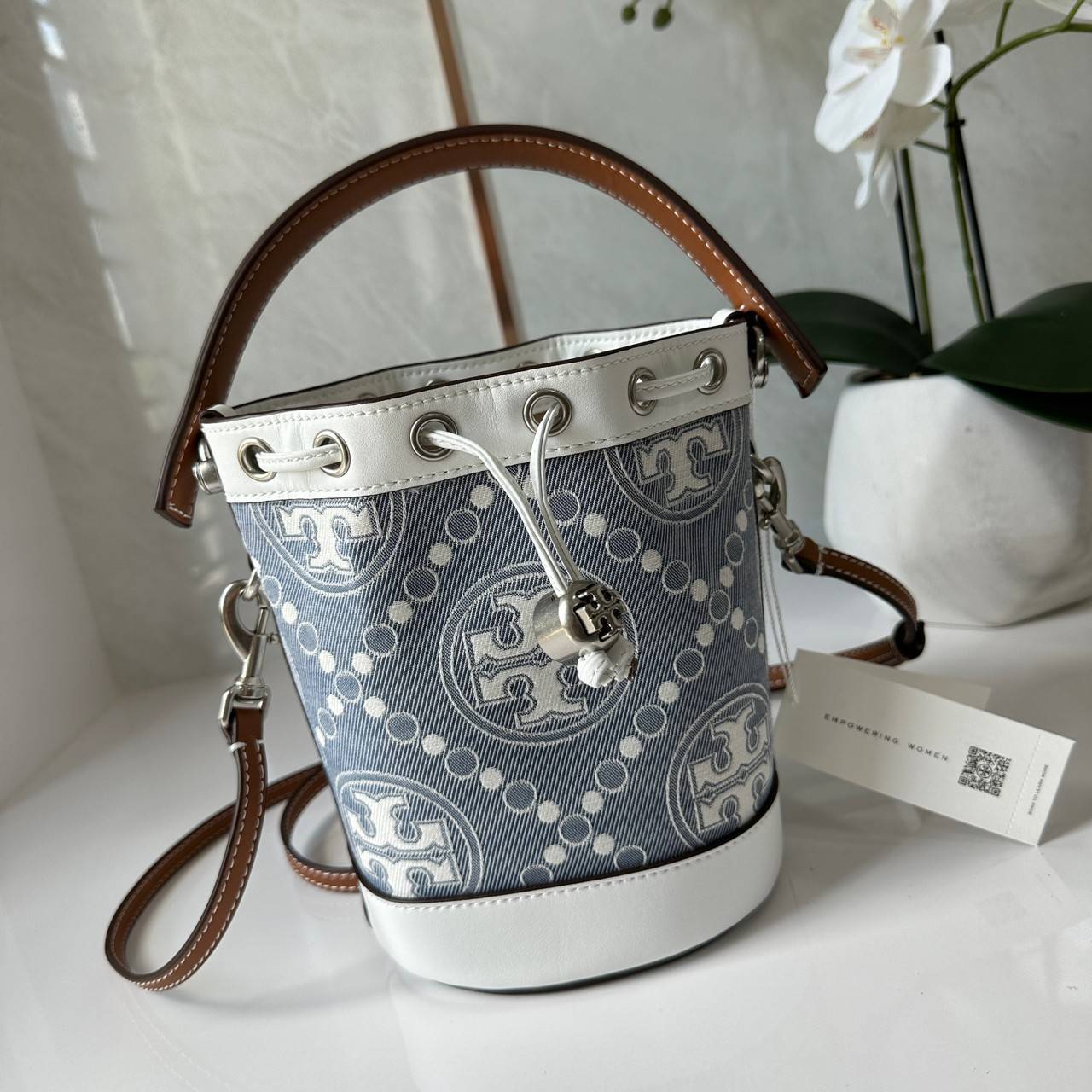 TORY BURCH Mini T Monogram Denim Bucket Bag คอลเลคชั่นใหม่ รูปแบบคลาสสิค พกพาความหรูหราไปได้ทุกที่ด้วยกระเป๋าทรง Bucket ขนาดกลางและปิดด้วยเชือกรูดพร้อมโลโก้แวววาว วัสดุผ้าเดนิมแจ็คการ์ด ตัดขอบหนังแท้ สวยหรู ทันสมัยสุดๆคะ