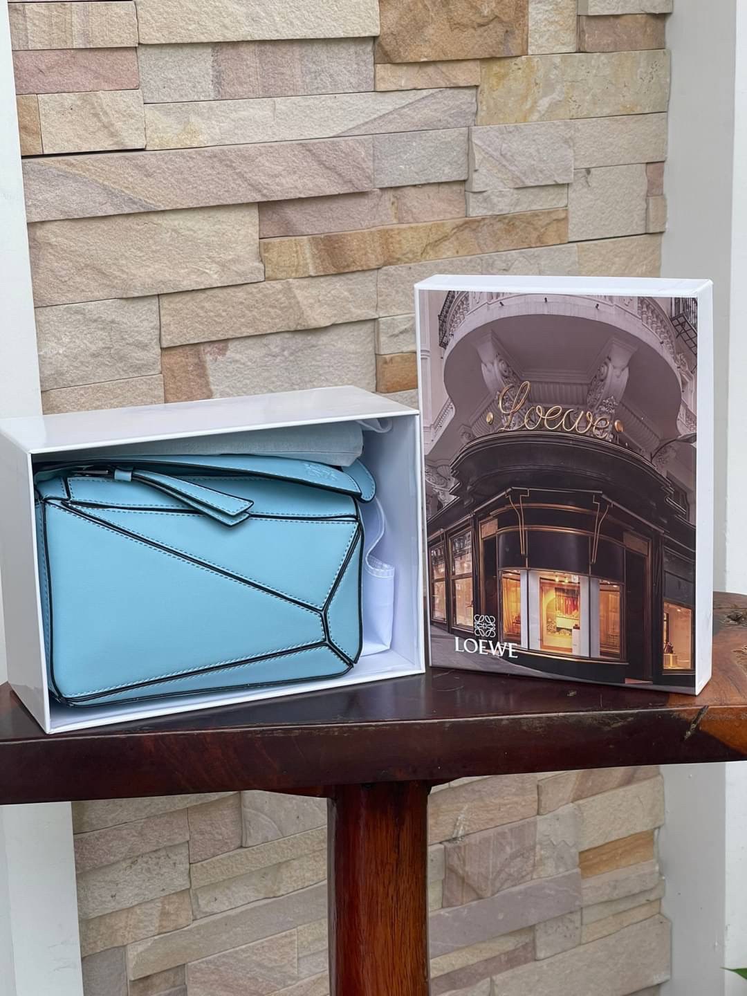 Loewe Nano Puzzle bag in classic โลเอเว่ (LOEWE) อีกหนึ่งกระเป๋าแบรนด์ดังจากสเปน ภายใต้คอลเลคชั่นใหม่อันร่วมสมัยของแบรนด์ มีความเป็นคลาสสิคและโมเดิร์นทันสมัย กระเป๋าที่มาในรูปแบบสี่เหลี่ยมผืนผ้า ที่สามารถใช้งานได้ทั้งแบบหูหิ้ว และแบบ Crossbody ด้านในมีช่อ