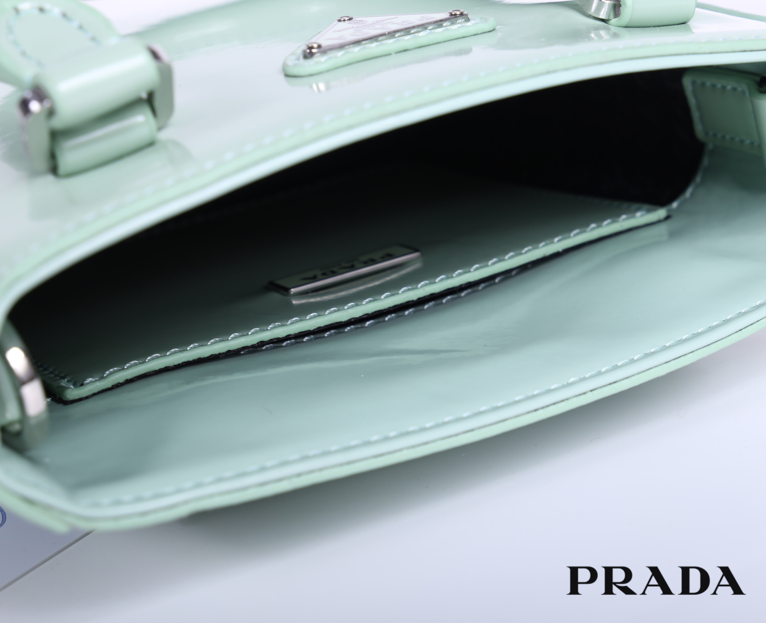 PRADA Small brushed leather tote กระเป๋าTote ขนาดเล็กที่มีดีไซน์ทรงเหลี่ยมโฉบเฉี่ยว วัสดุจากหนังเงาซึ่งเป็นวัสดุที่โดดเด่นของแบรนด์มาตั้งแต่ยุค 90'