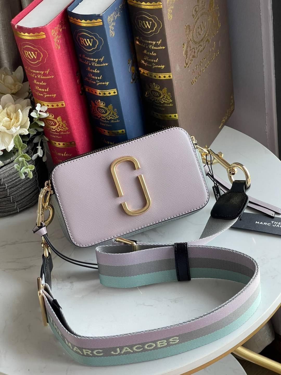 Marc Jacobs Snapshot Bag กระเป๋าแบรนด์ดังจากสัญชาติอเมริกัน นับได้ว่ารุ่นนี้เป็นรุ่นทรงฮิตเลยทีเดียว โดยด้านหน้ากระเป๋าจะเป็นโลโก้แบบโลหะที่เป็นสัญลักษณ์ของแบรนด์นี้ มาพร้อมสายสะพายที่จะสะพายยังไงก็ดูโดดเด่น เพราะขนาดใหญ่ที่สกรีนตัวอักษรโลโก้ ในรูปแบบต่าง