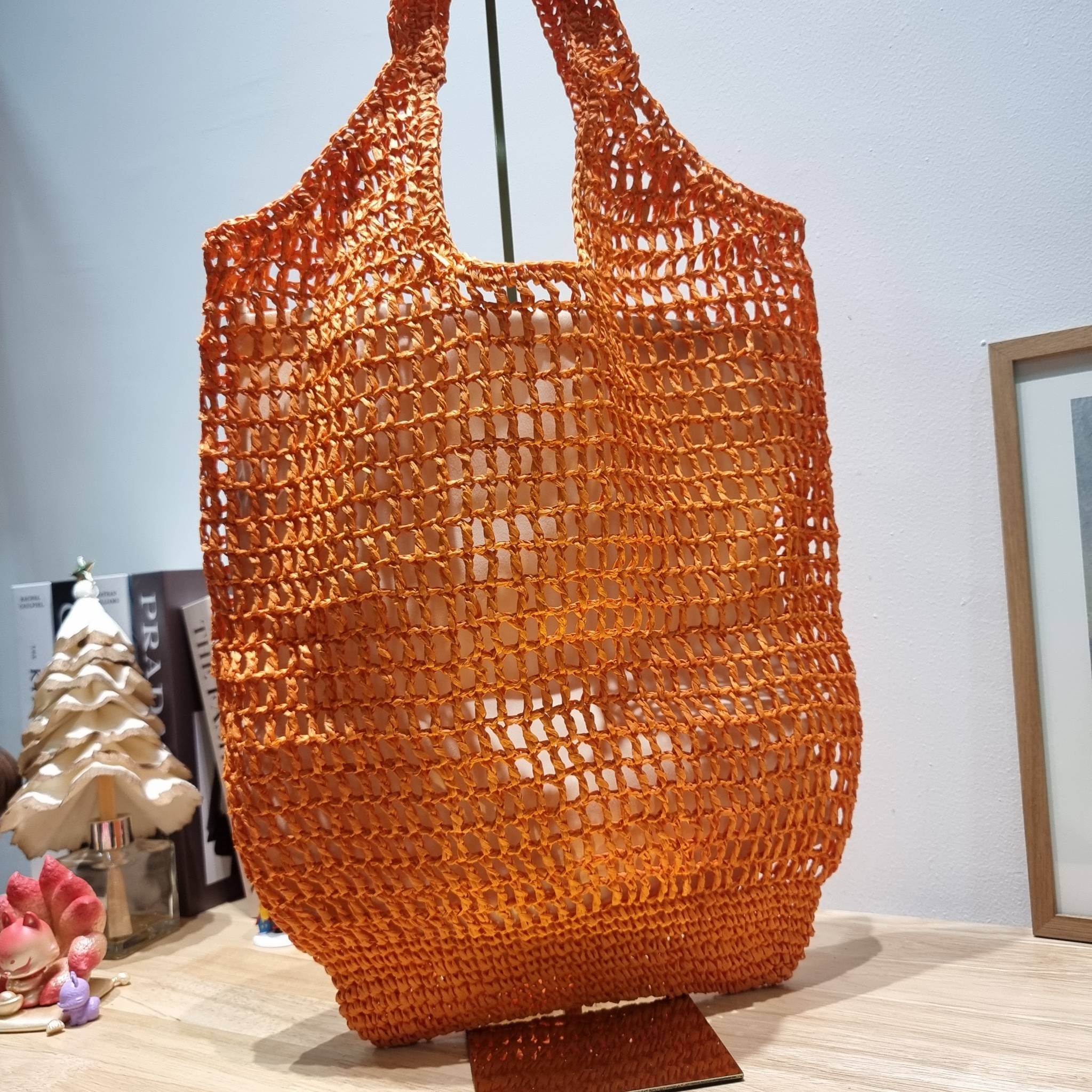 PRADA RAFFIA TOTE BAG สวยไม่ซ้ำใคร สไตล์บีช เหมาะมากกับการสะพายไปเที่ยวทะเล หรือจะใช้ในวันสบายๆก็ตอบโจทย์ กับกระเป๋าสะพายสานใบใหญ่ ตัวกระเป๋าเป็นวัสดุสังเคราห์จากธรรมชาติ สานทอเต็มใบออกมาเป็นลวดลายสวยงาม