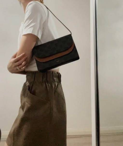 CELINE WALLET ON STRAP IN TRIOMPHE CANVAS กระเป๋าสะพายไหล่สุดเก๋ใบนี้ผลิตจากผ้าใบเคลือบอย่างดีพร้อมขอบหนังสีน้ำตาล กระเป๋ามีสายสะพายหนังสีน้ำตาลพร้อมฮาร์ดแวร์สีทอง ถอดสายออกเพื่อเป็นกระเป๋าถือทรงคลัชท์เปลี่ยนลุคช์ ลวดลายtriomphe ความเป็นแบรนด์ CELINE ได้อ