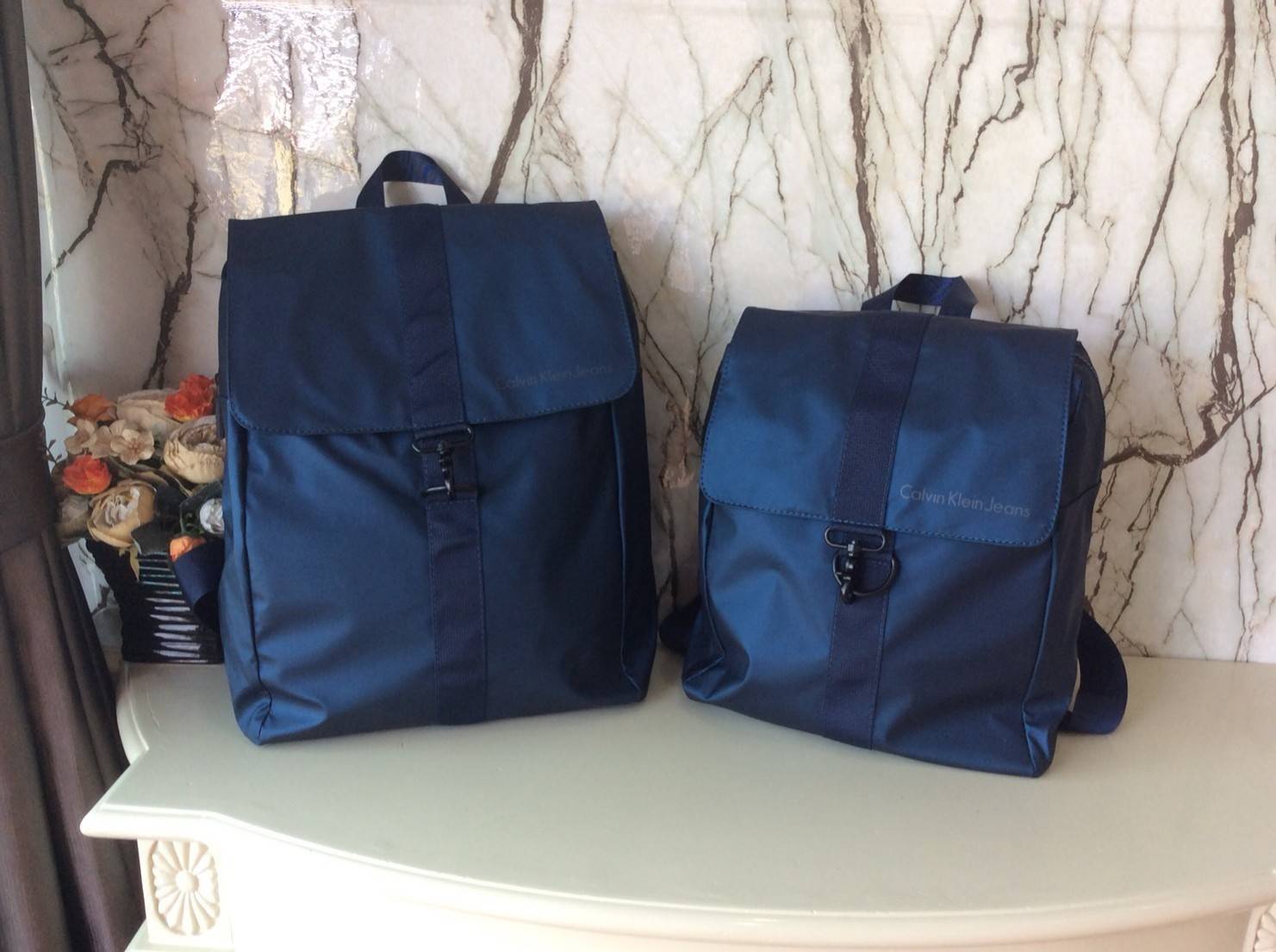 CALVIN KLEIN JEANS NYLON BACKPACK กระเป๋าสะพายเป้มี 2 size ให้เลือกตามการใช้งาน วัสดุ Nylon + Polyester 100% น้ำหนักเบา กันน้ำปานกลาง ด้านหน้าสกรีนโลโก้ Calvin Klein Jeans เปิดปิด 2 ชั้น ด้วยตัวล็อค เเละซิปเดียวด้าน ภายในกว้าง ใส่ A4, iPad หรือเสื้อผ้าได้