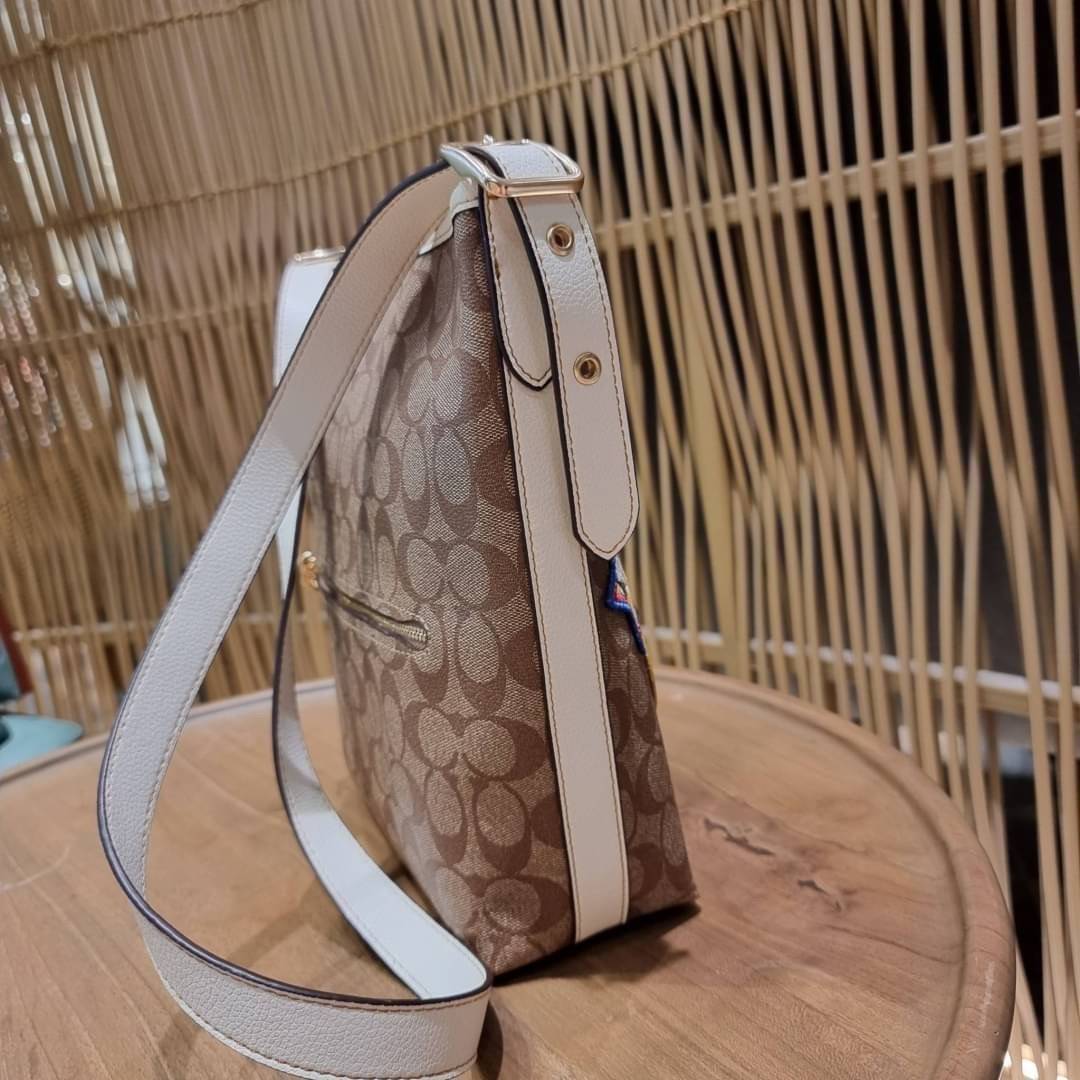 OUTLET 】COACH C4112 COACHxPEANUTS VAL DUFFLE IN SIGNATURE CANVAS WITH VARSITY PATCHES ใหม่ล่าสุด กระเป๋าทรงดัฟเฟิล ที่มาพร้อมเหล่าผองเพื่อนสนูปพี สวยมีเอกลักษณ์ ทรงกระเป๋าไม่ซ้ำใคร แถมยังใส่ของได้จุใจไปอีก วัสดุหนังแคนวาสคุณภาพดี ด้านหลังมีช่องซิป กระเป๋า