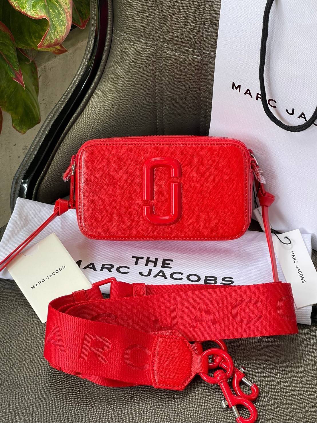 Marc Jacobs Snapshot Bag กระเป๋าแบรนด์ดังจากสัญชาติอเมริกัน นับได้ว่ารุ่นนี้เป็นรุ่นทรงฮิตเลยทีเดียว โดยด้านหน้ากระเป๋าจะเป็นโลโก้แบบโลหะที่เป็นสัญลักษณ์ของแบรนด์นี้ มาพร้อมสายสะพายที่จะสะพายยังไงก็ดูโดดเด่น เพราะขนาดใหญ่ที่สกรีนตัวอักษรโลโก้ ในรูปแบบต่าง