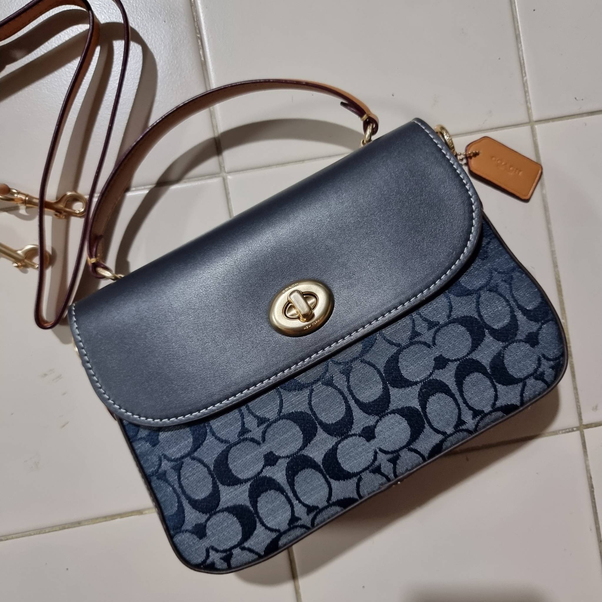 COACH C4921 MARLIE TOP HANDLE SATCHEL IN SIGNATURE CHAMBRAY กระเป๋าถือ/สะพายข้าง มีดีไซน์ยูนีค โดดเด่น ตกแต่งโลโก้ด้านข้างอะไหล่ทอง วัสดุผ้าแชมเบรย์ ทอเส้นลายสวย เปิด-ปิดด้วยตัวล็อคแน่นหนา ภายในเป็นช่องโล่ง ใส่ของได้ครบครัน มาพร้อมหูจับในตัวและสายสะพายข้า