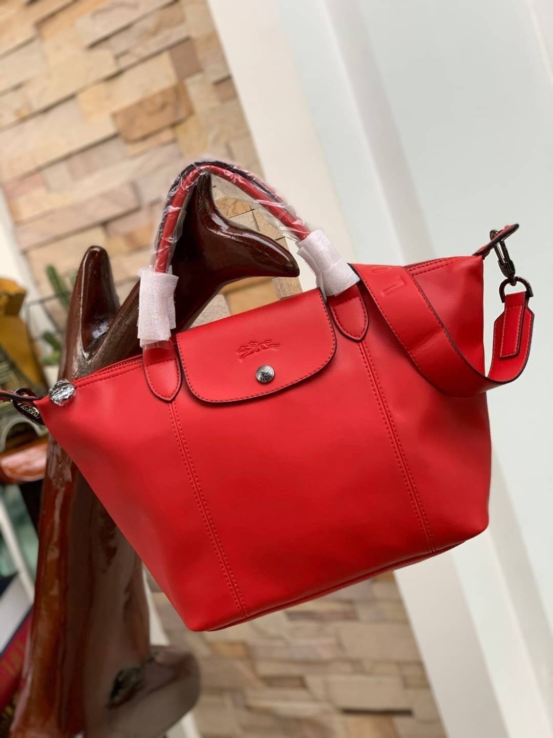 Longchamp LE PLIAGE CUIR TOP HANDLE BAG S เรียกว่าเป็นกระเป๋าอีกหนึ่งรุ่นที่ไม่ว่ายังไงก็ฮอตฮิตและติดเทรนด์ตลอดไม่เคยเปลี่ยนกับ ทรง Le Pliage Cuir หนึ่งในตระกูลกระเป๋าสุดไอคอนิกจากแบรนด์ เมื่อรุ่น Le Pliage Cuir ในรูปแบบของหนังแกะ Metis ได้ถือกำเนิดขึ้นใน