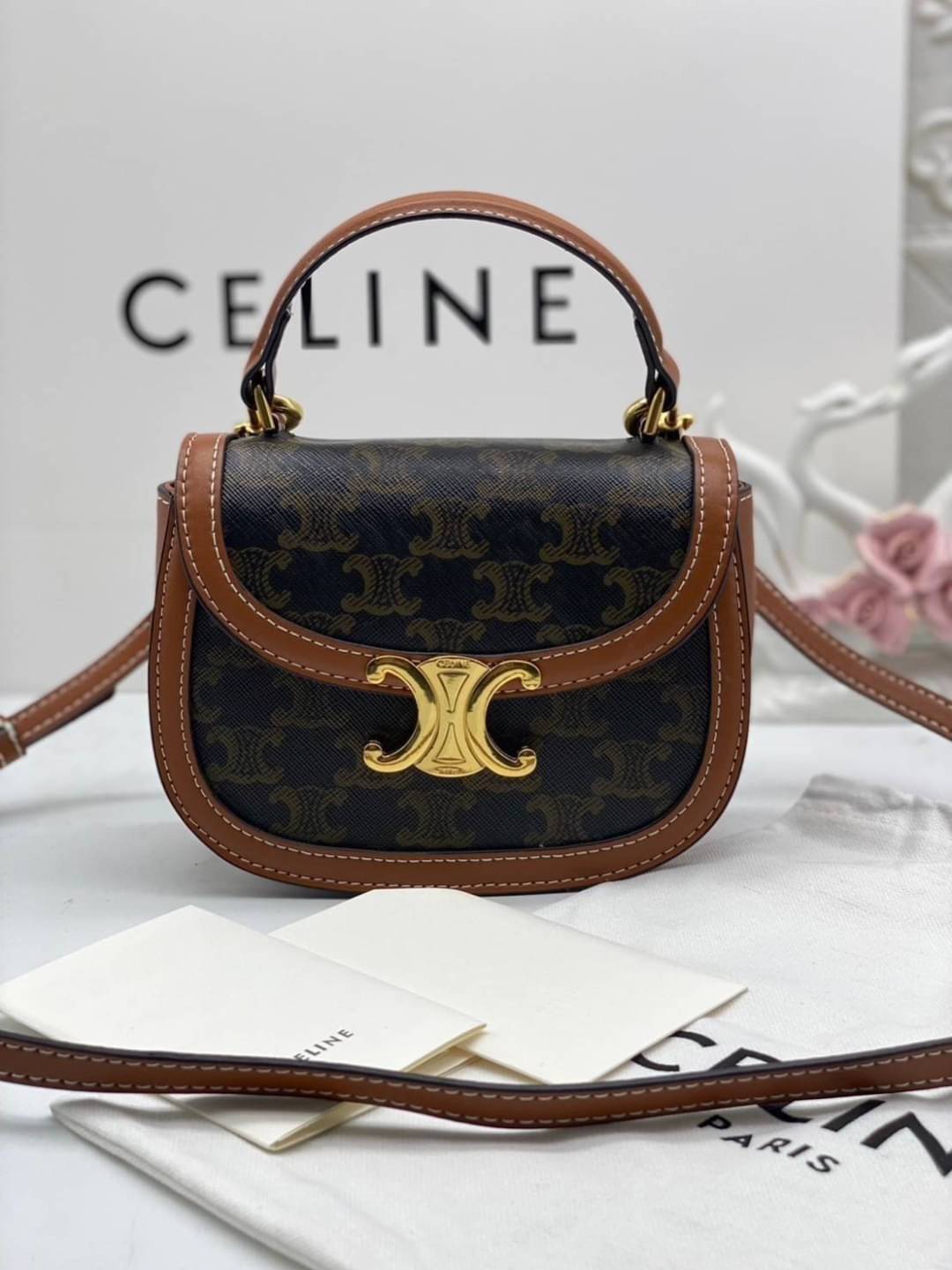 CELINE Mini besace triomphe in shiny top handle กระเป๋าสะพายคาดลำตัวพร้อมหูจับถนัดมือ ได้รับความนิยมอย่างมาก ด้วยรูปร่างทรงโค้งมนมีความคลาสสิกตามแบบฉบับแบรนด์