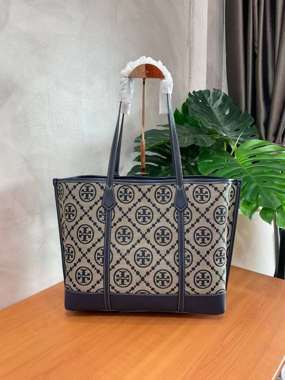 TORY BURCH T MONOGRAM TRIPLE - COMPARTMENT TOTE กระเป๋า/สะพายไหล่ทรง SHOPPING BAG วัสดุผ้าผ้าแคสวาสปักลายสัญลักษณ์แบรนด์ ตั้งอยู่ทรง สวยหรู ดูแพง จุของได้เยอะมาก ภายในแยกเป็น 2 ช่องหลัก 1 ช่องซิปตรงกลาง แบ่งเป็นสัดส่วนใช้งาน